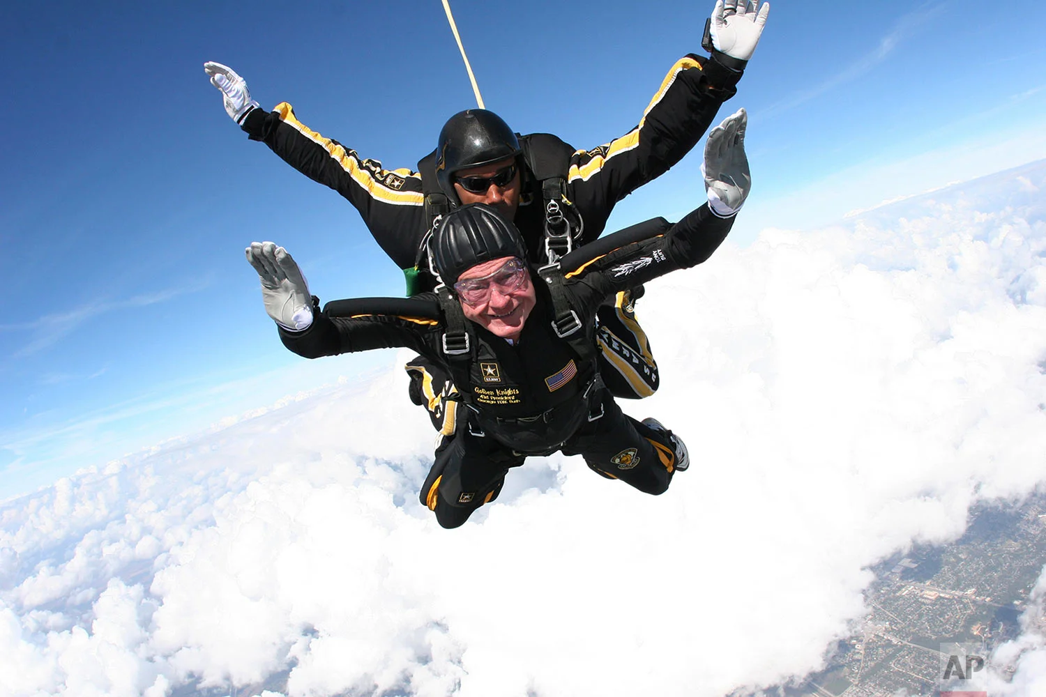 In this provided by the U.S. Army Golden Knights, former President George H.W. Bush free falls with Golden Knights parachute team member Sgt. 1st Class Mike Elliott, as he makes a dramatic entrance to his presidential museum on Nov. 10, 2007, during a rededication ceremony in College Station, Texas. (Sgt. 1st Class Kevin McDaniel/U.S. Army via AP)