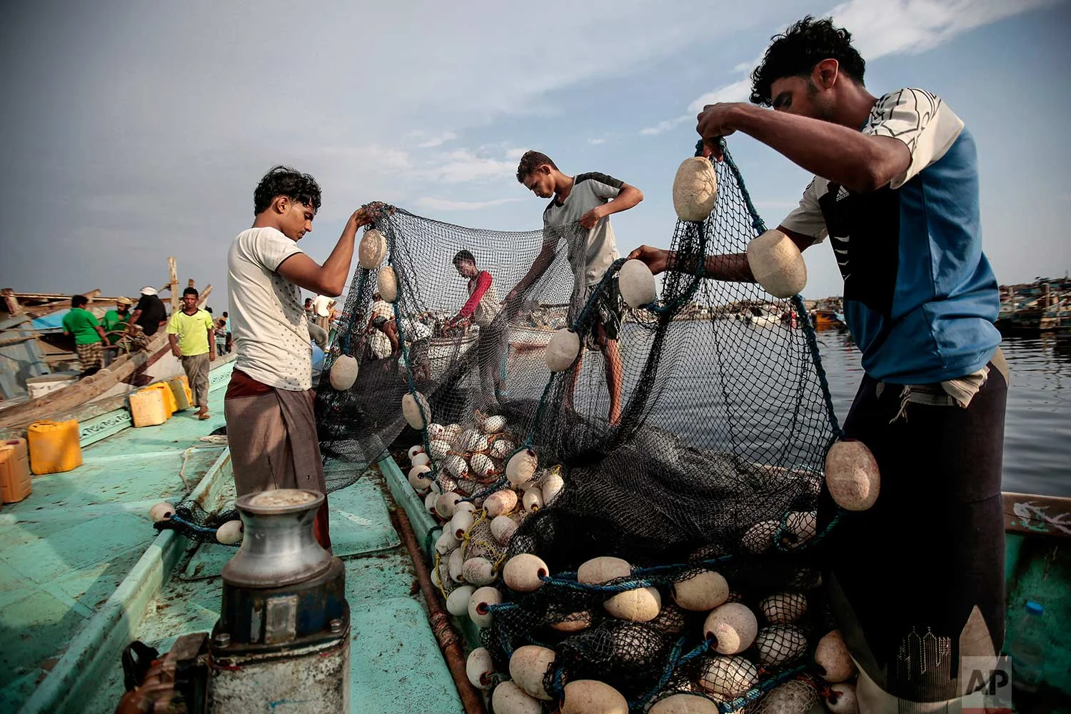 In this Sept. 29, 2018 photo, Yemeni fishermen load their nets on to a boat before a fishing trip at the main fishing port, in Hodeida, Yemen. (AP Photo/Hani Mohammed)