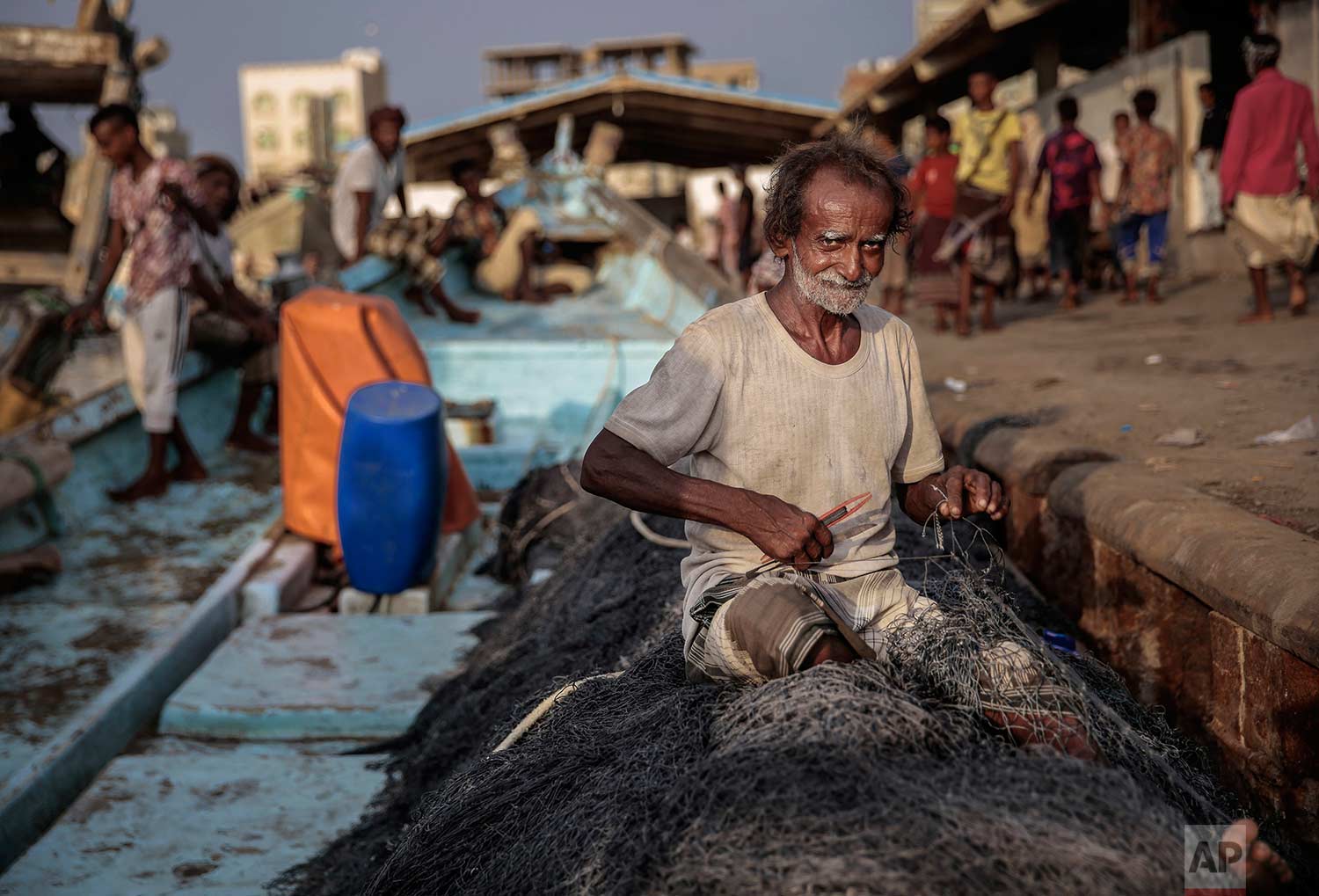 In this Sept. 29, 2018, photo, 71-year-old Yemeni fisherman Ammar Ahmed prepares his nets before a fishing trip at the main fishing port, in Hodeida, Yemen. (AP Photo/Hani Mohammed)
