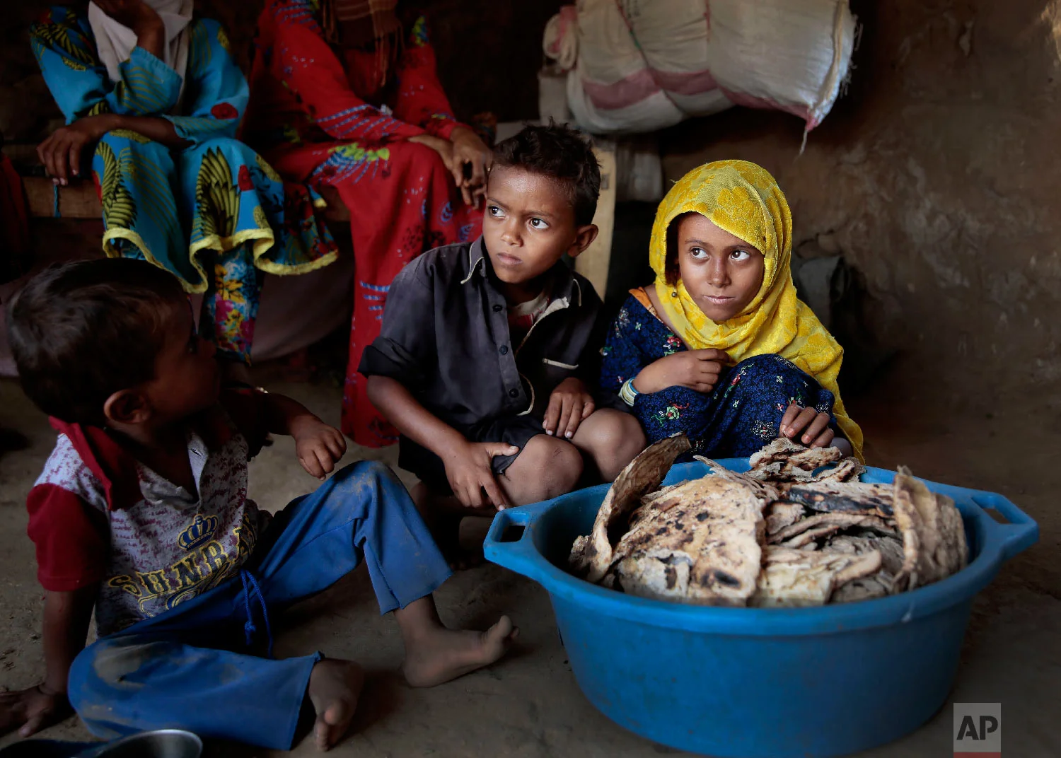 Children sit in front of moldy bread in their shelter, in Aslam, Hajjah, Yemen. (AP Photo/Hani Mohammed)