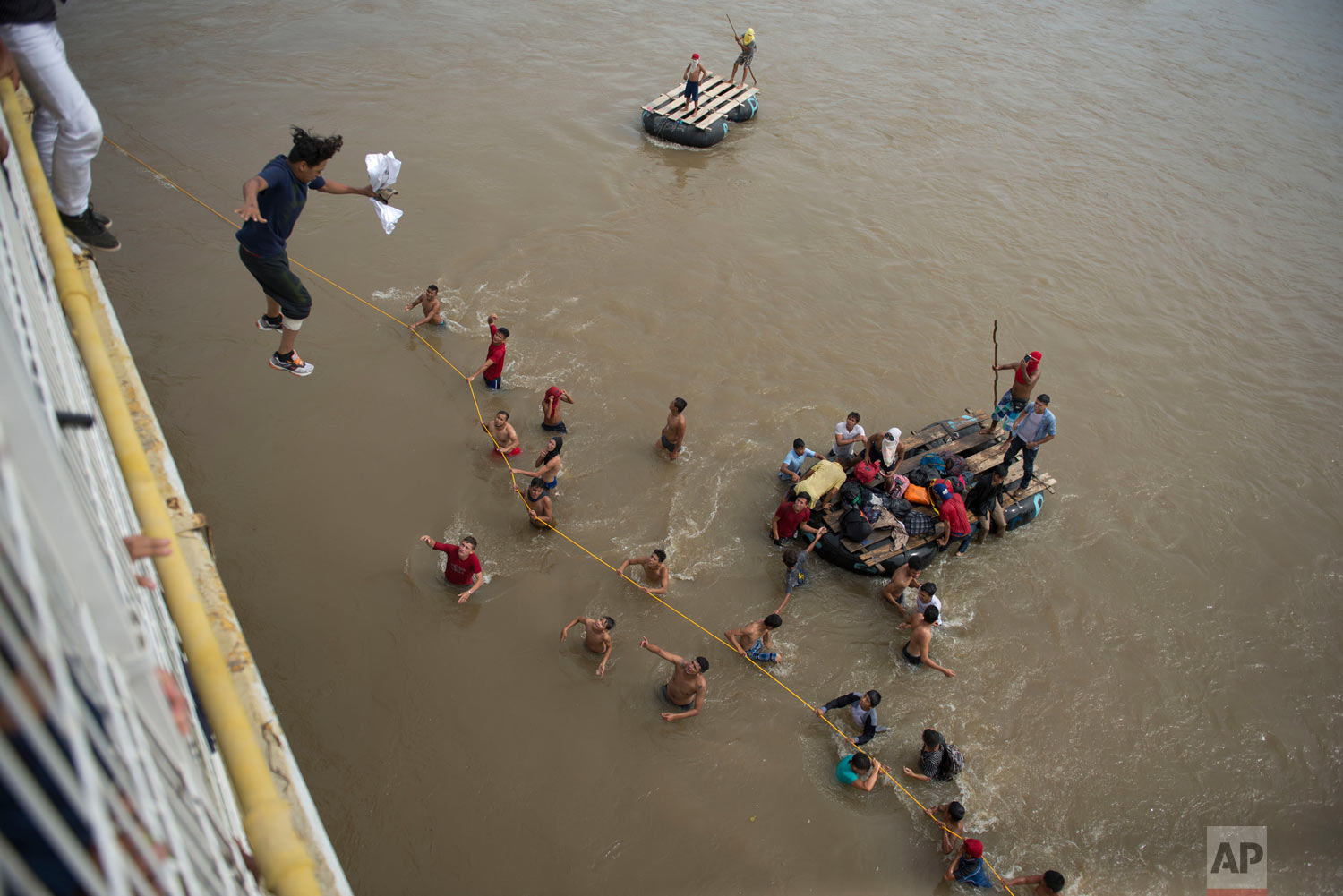  Migrants tired of waiting to cross into Mexico jump from a border bridge into the Suchiate River in Tecun Uman, Guatemala, Friday, Oct. 19, 2018, as a second caravan makes its way to the U.S. Some of the migrants traveling in a mass caravan towards 