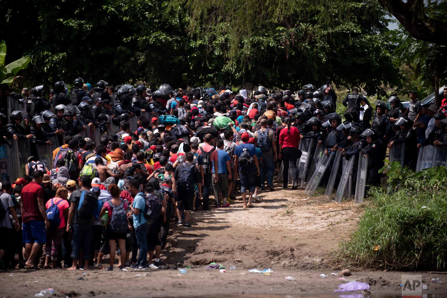 A second group of Central American migrants are met by Mexican Federal Police after they waded in mass across the Suchiate River, which connects Guatemala and Mexico, in Tecun Uman, Guatemala, Monday, Oct. 29, 2018. The first group was able to cross the river on rafts, an option now blocked by Mexican Navy river and shore patrols, but police eventually allowed their passage. (AP Photo/Santiago Billy)