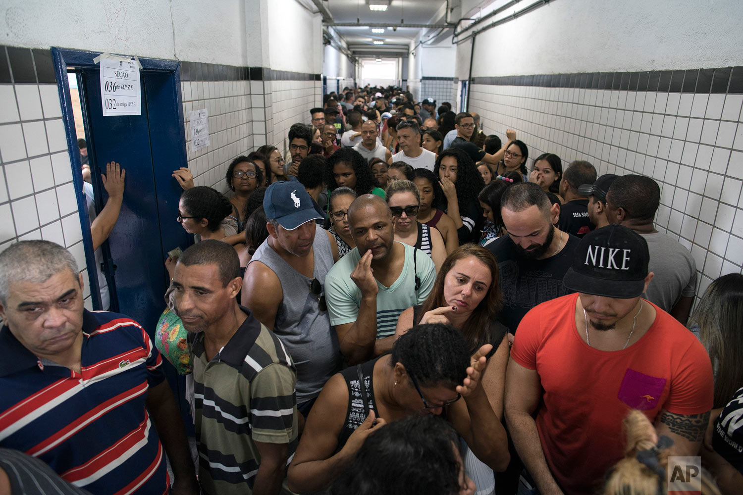  People wait in line to vote in the general election at a polling station in the Mare Complex slum in Rio de Janeiro, Brazil, Oct. 7, 2018. Brazilians choose among 13 candidates for president Sunday in one of the most unpredictable and divisive elect