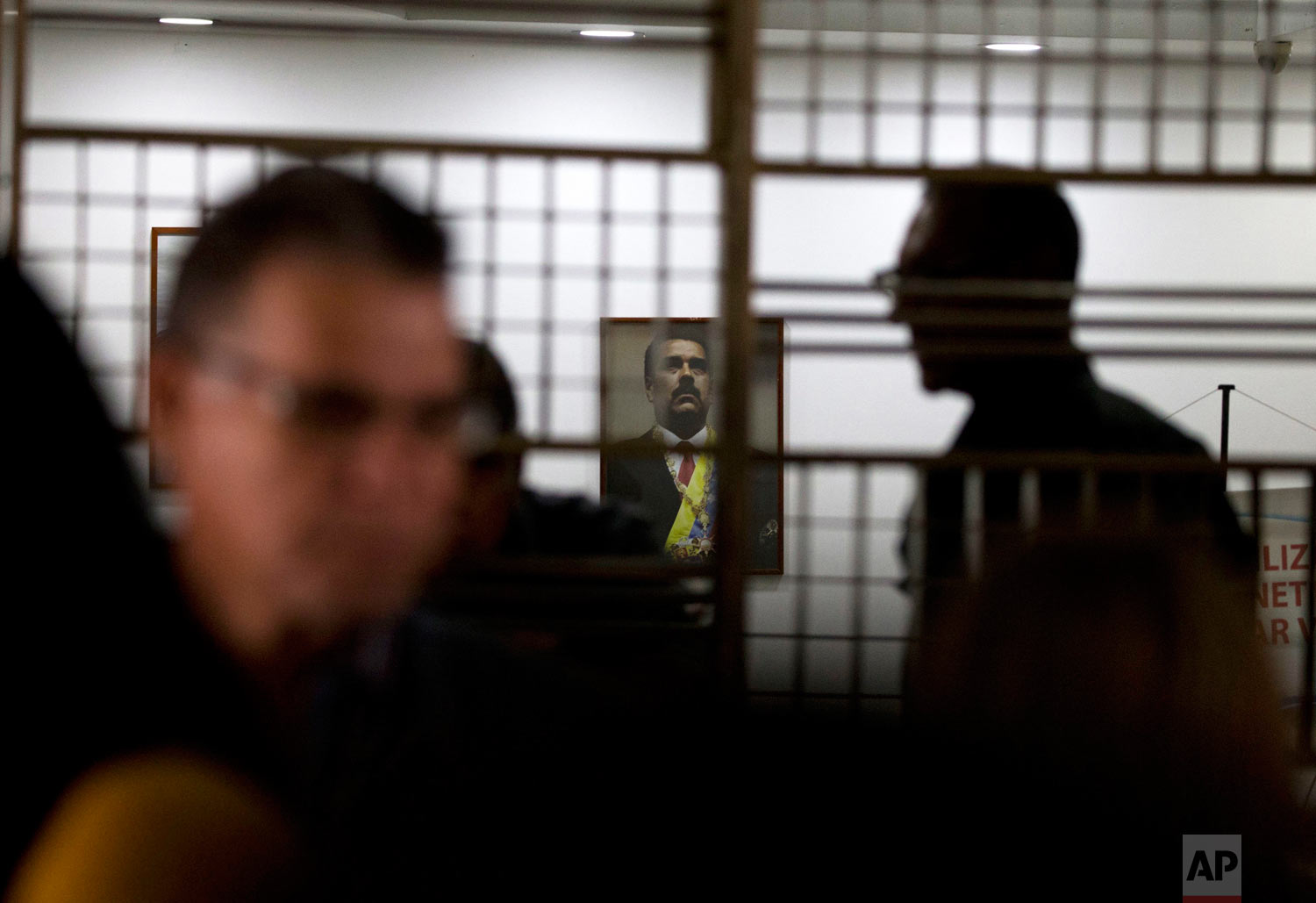  An image of Venezuela's President Nicolas Maduro hangs above the main desk at the Labor Ministry as workers demanding better wages protest outside the building, in Caracas, Venezuela, Oct. 5, 2018. (AP Photo/Fernando Llano) 