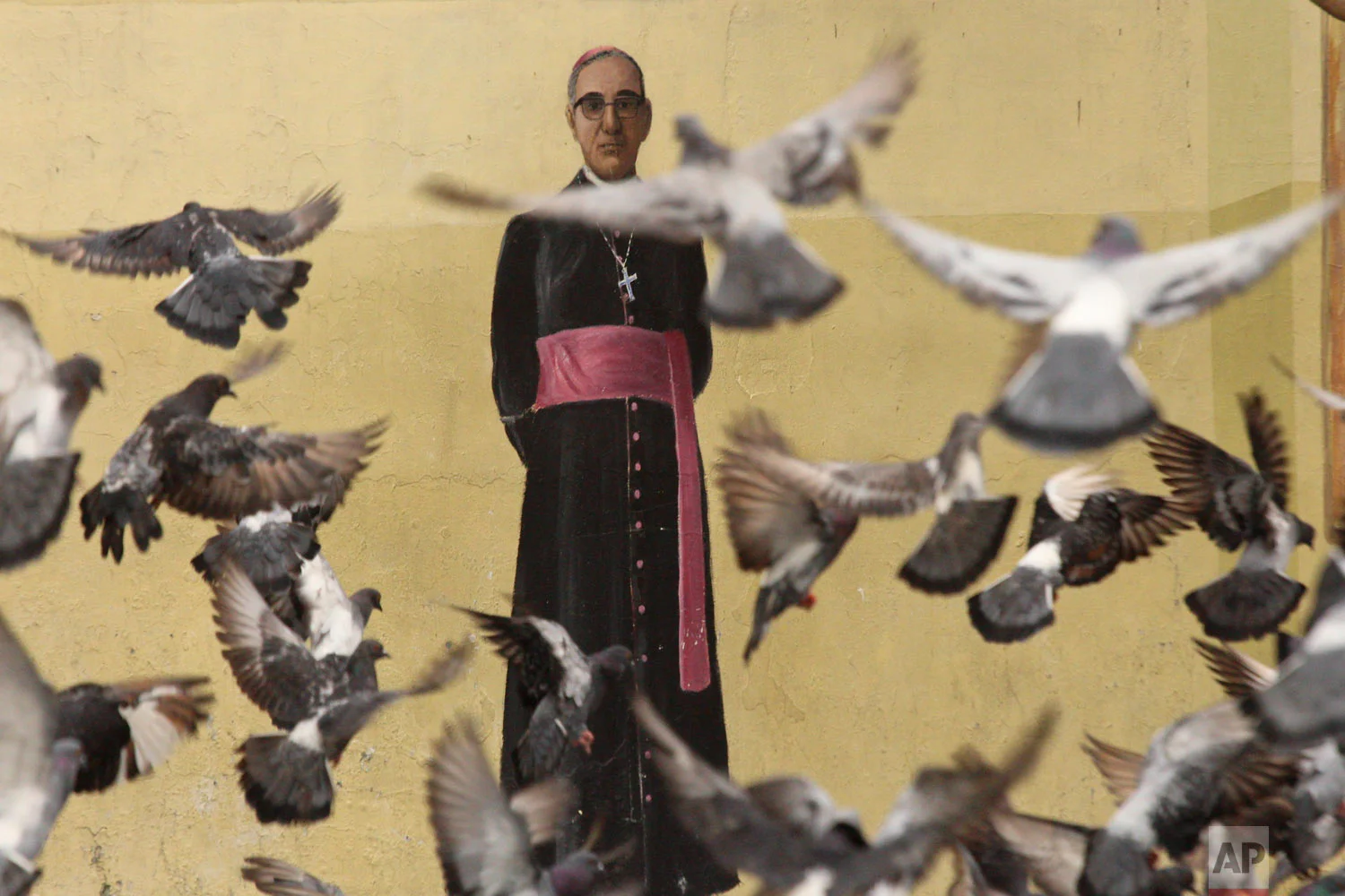 Pigeons fly in front of a mural of Archbishop Oscar Arnulfo Romero, on a wall of the Metropolitan Cathedral in San Salvador, El Salvador, Oct. 3. 2018. Romero will be canonized in Rome by Pope Francis on Sunday, Oct. 14th. Romero was assassinated in 1980 while celebrating Mass by a gunman hired by right-wing death squads. (AP Photo/Salvador Melendez)