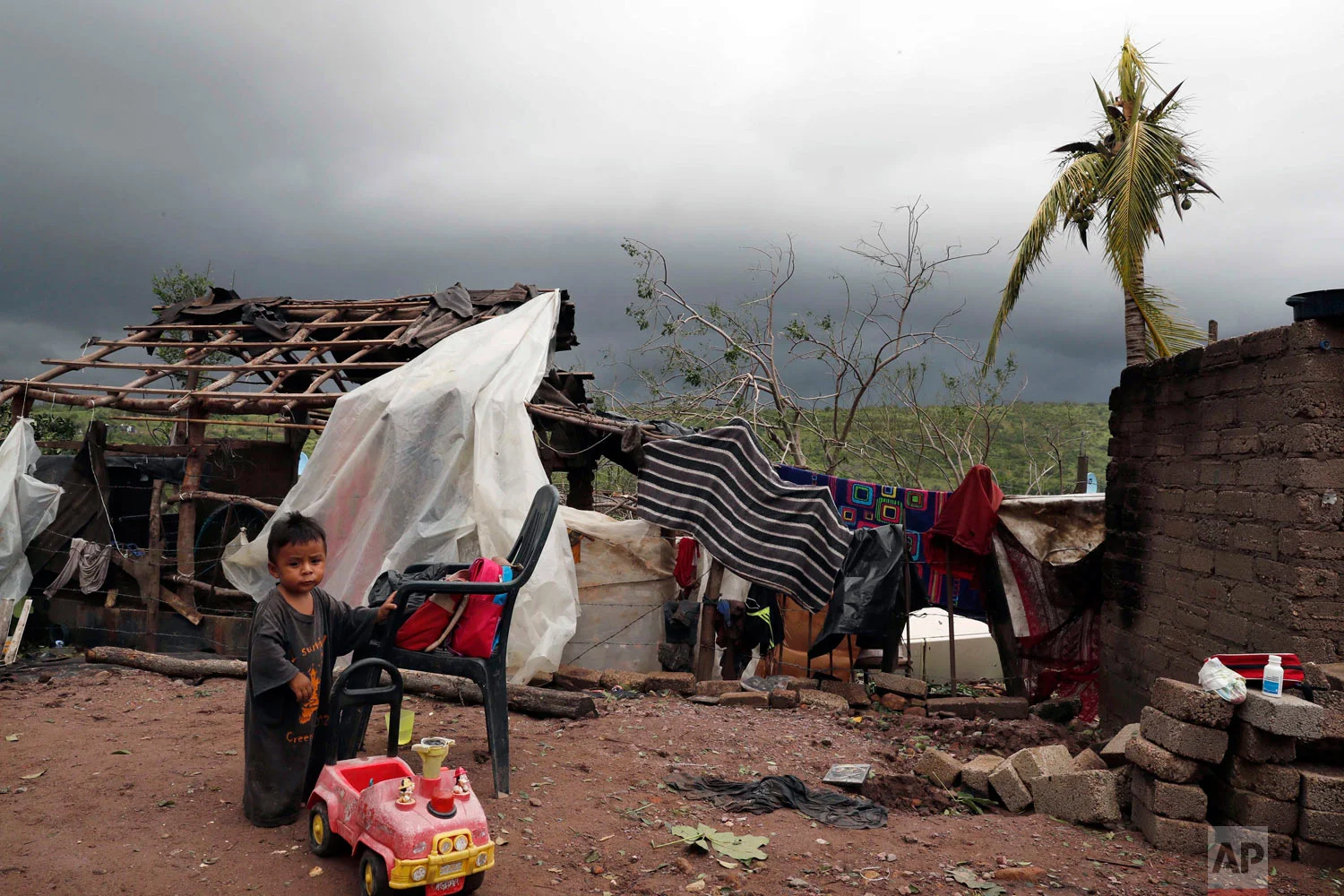 A child stands near his home damaged by Hurricane Willa in Escuinapa, Mexico, Oct. 24, 2018. There were no immediate reports of deaths or missing people, but Willa's strong winds damaged a hospital, knocked out power, toppled wood-shack homes and ripped metal roofing off other houses in the Sinaloa state municipality of Escuinapa when it came ashore. (AP Photo/Marco Ugarte)