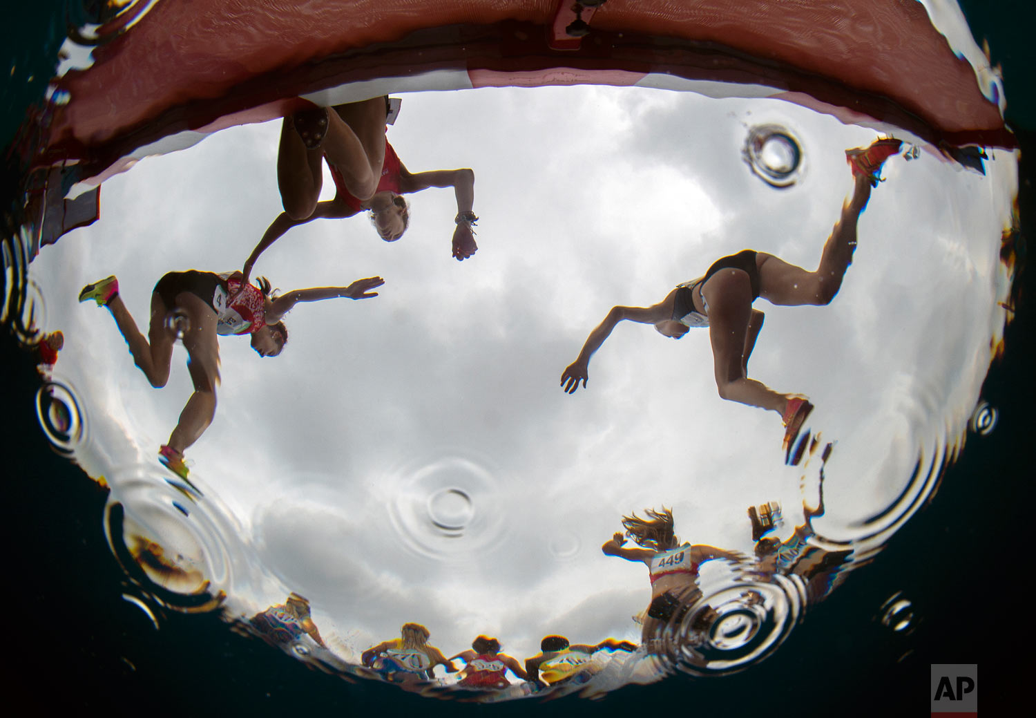  In this photo provided by the OIS/IOC, athletes are reflected in water during the Women's Athletics 3000m during the Youth Olympic Games in Buenos Aires, Argentina, Oct. 12, 2018. (Joel Marklund/OIS/IOC via AP) 