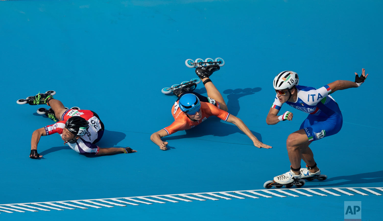  In this photo provided by the OIS/IOC, Italy's Vincenzo Maiorca takes the lead as Taiwan's Chiawei Chang, center, and The Netherland's Merijn Scheperkamp fall during the Roller Speed Skating Men's Combined Speed Event during the Youth Olympic Games 