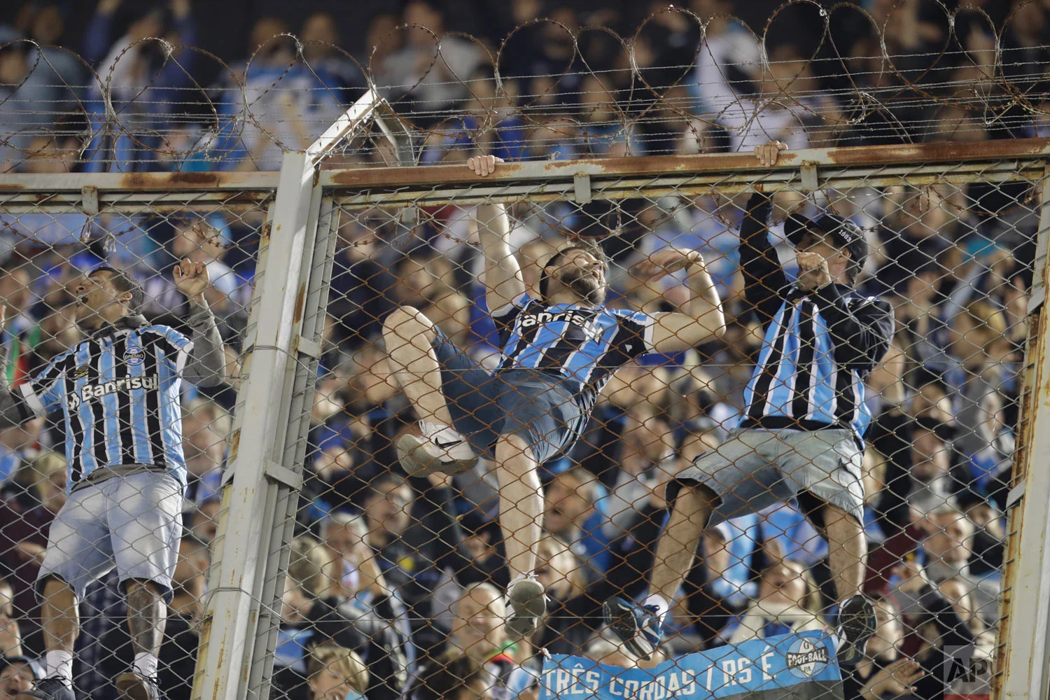 Fans of Brazil's Gremio celebrate on the fence after Michel's goal against Argentina's River Plate during a Copa Libertadores semifinal first leg soccer match in Buenos Aires, Argentina, Oct. 23, 2018. Gremio won 1-0. (AP Photo/Natacha Pisarenko)