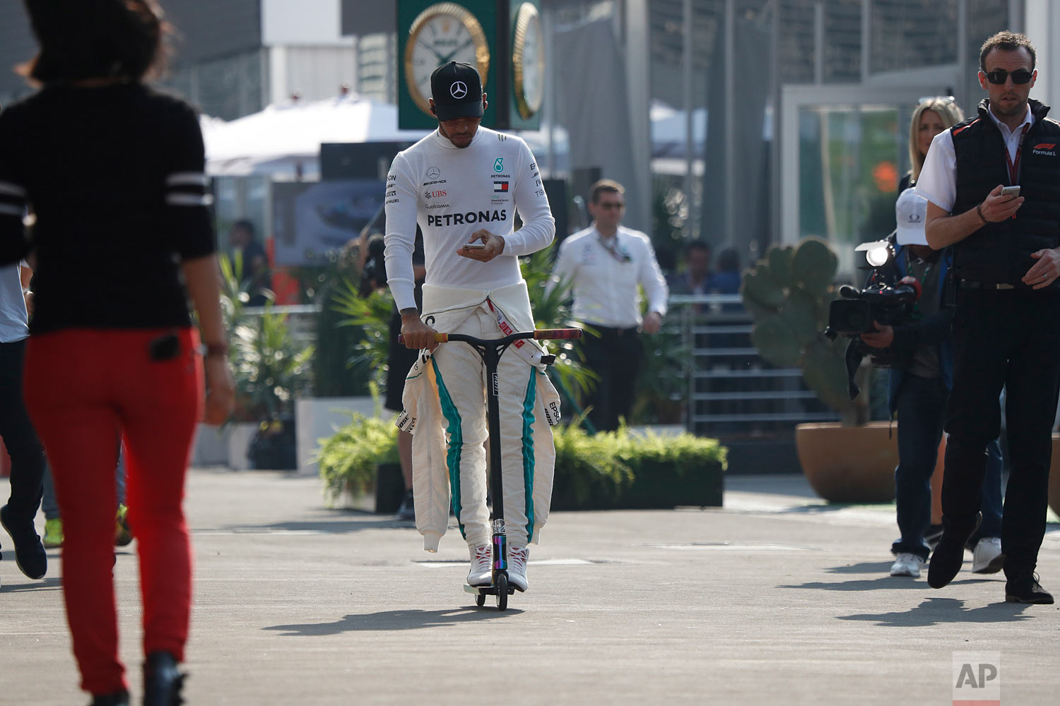  Mercedes driver Lewis Hamilton, of Britain, rides a scooter to the pit lane ahead of the first training session of the Formula One Mexico Grand Prix auto race at the Hermanos Rodriguez racetrack in Mexico City, Oct. 26, 2018. (AP Photo/Moises Castil
