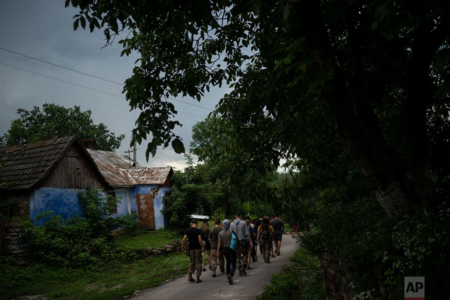 Young participants of the "Temper of will" summer camp, organized by the nationalist Svoboda party, walk to a campsite on July 27, 2018, in a village near Ternopil, Ukraine. (AP Photo/Felipe Dana)