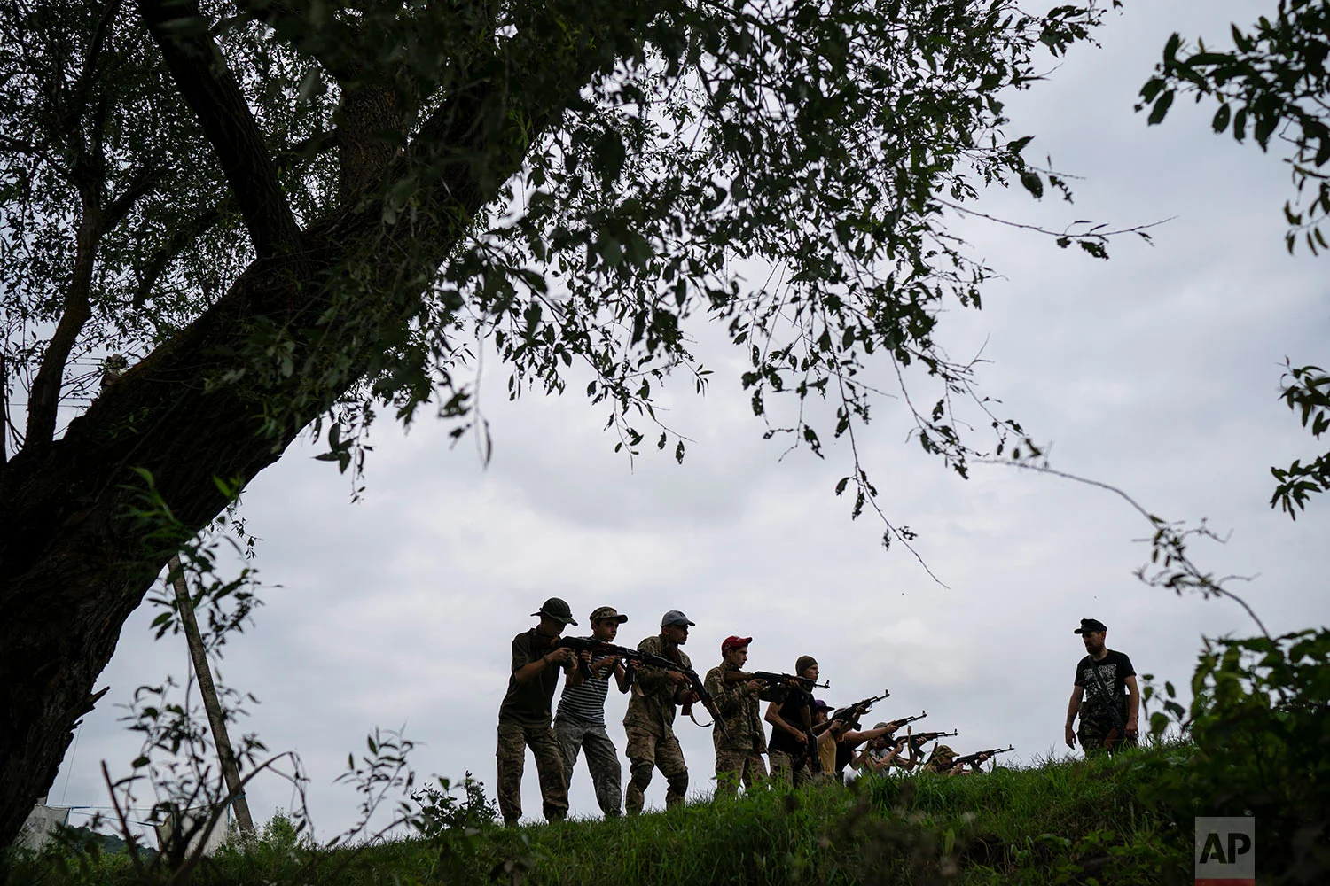 Yuri Chornota Cherkashin, right, head of Sokil, gives tactical instructions to young participants of the "Temper of will" summer camp, organized by Svoboda party on July 29, 2018, in a village near Ternopil, Ukraine. (AP Photo/Felipe Dana)