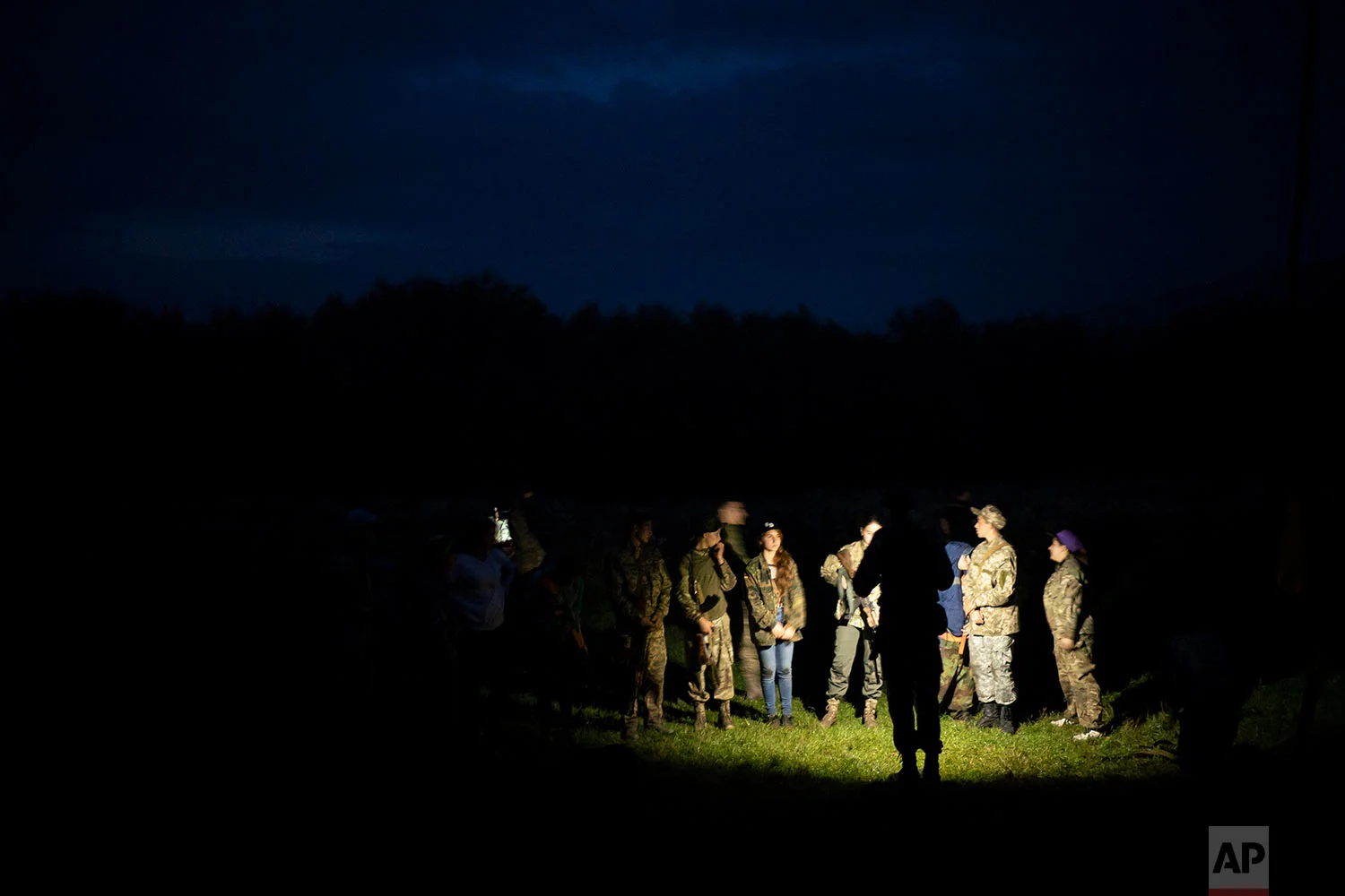 Young participants of the "Temper of will" summer camp, organized by the nationalist Svoboda party, receive instructions on July 28, 2018, in a village near Ternopil, Ukraine. (AP Photo/Felipe Dana)