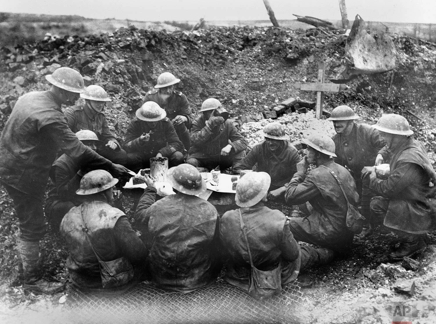 In this undated photo, Allied soldiers eat and drink in a shell hole in France during World War One. (AP Photo)