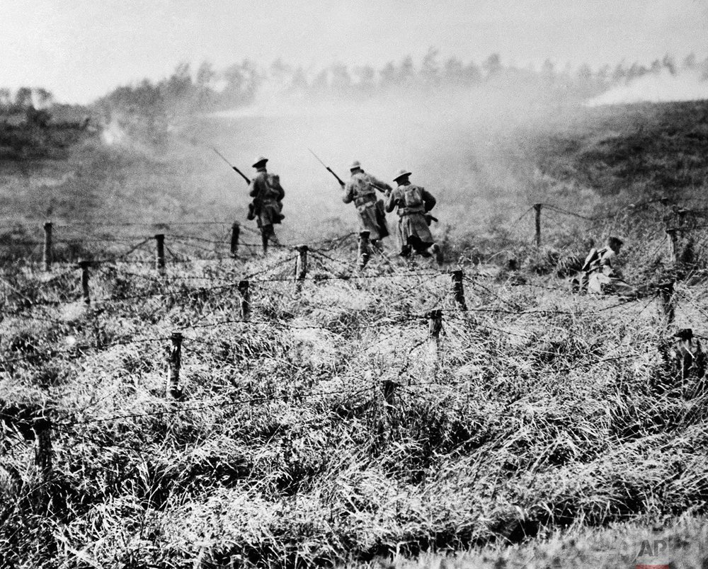  In this Sept. 13, 1918 photo, U.S. troops of the 107th Regiment Infantry, 27th Division, advance on a path through a barbed wire entanglement near Beauqueanes, Somme, France during World War One. (AP Photo/U.S. Army Signal Corps)

 