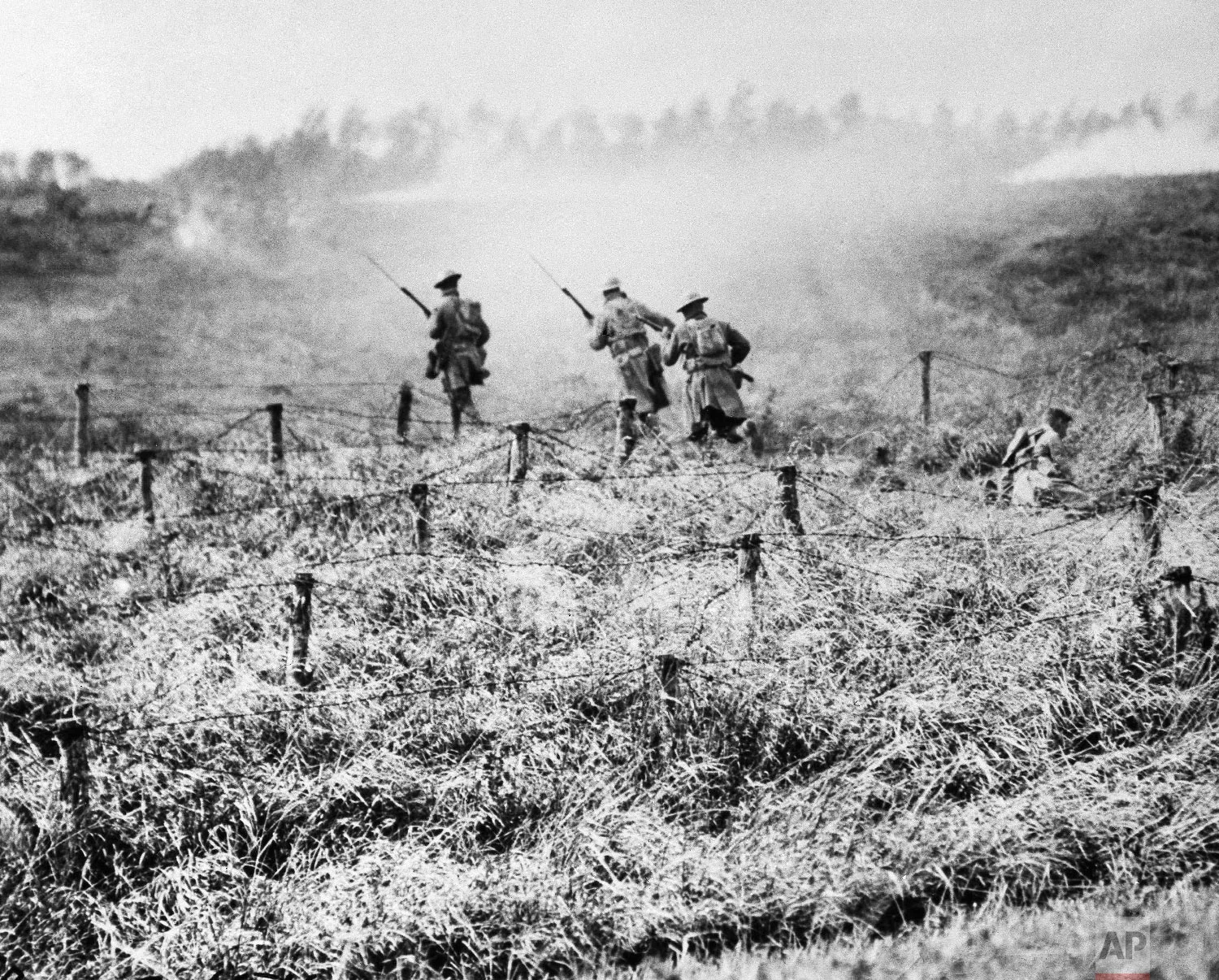 U.S. troops of the 107th Regiment Infantry, 27th Division, advance on a path through a barbed wire entanglement near Beauqueanes, Somme, France during World War One on Sept. 13, 1918. (AP Photo/U.S. Army Signal Corps)