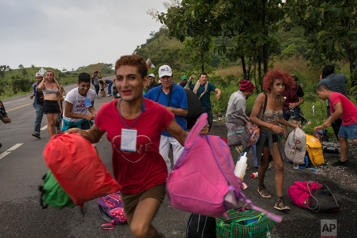  In this Nov. 2, 2018 photo, members of a LGBTQ group who are traveling with the Central American migrants caravan hoping to reach the U.S. border, run towards a truck who stopped to give them a ride, on the road to Sayula, Mexico. (AP Photo/Rodrigo 