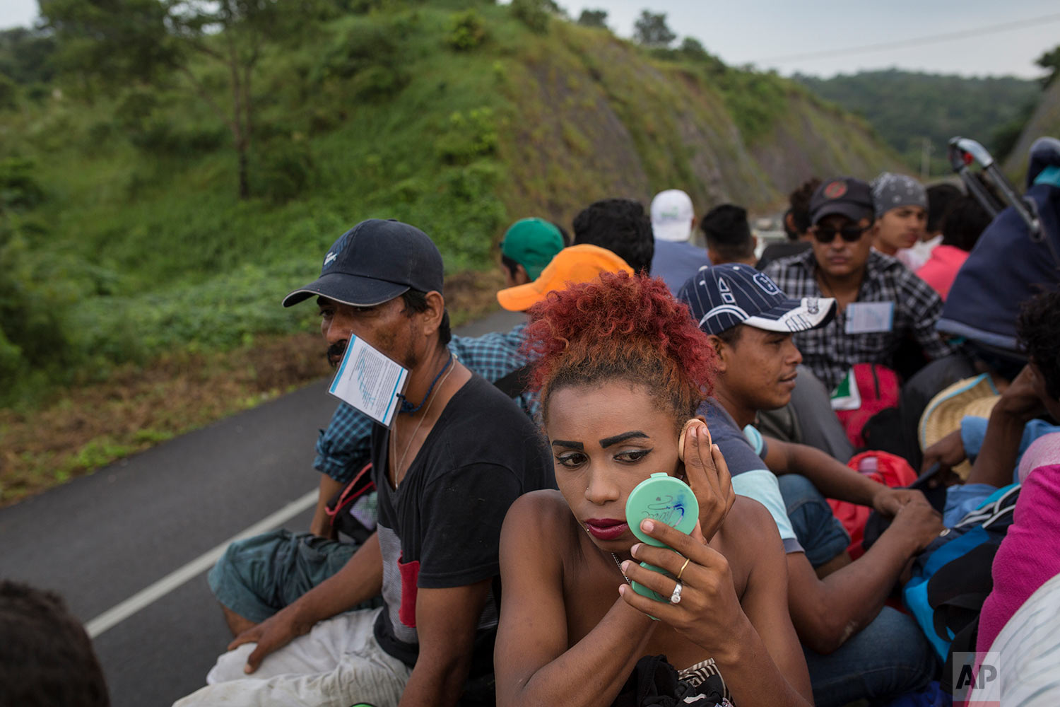  In this Nov. 2, 2018 photo, Honduran transgender Alexa Amaya, who is part of a group of 50 or so LGBTQ migrants traveling with the migrant caravan hoping to reach the U.S. border, uses a compact miror to apply makeup while riding in the back of a fl