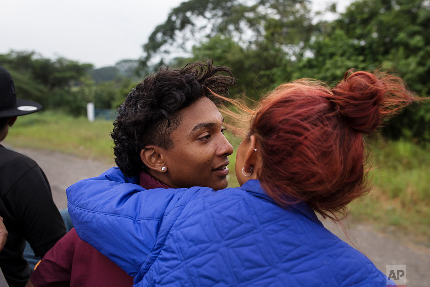  In this Nov. 2, 2018 photo, a couple who are part of a group of 50 or so LGBTQ migrants traveling with the migrant caravan hoping to reach the U.S. border, ride on the back of a flatbed truck as they make their way to Sayula, Mexico.  (AP Photo/Rodr