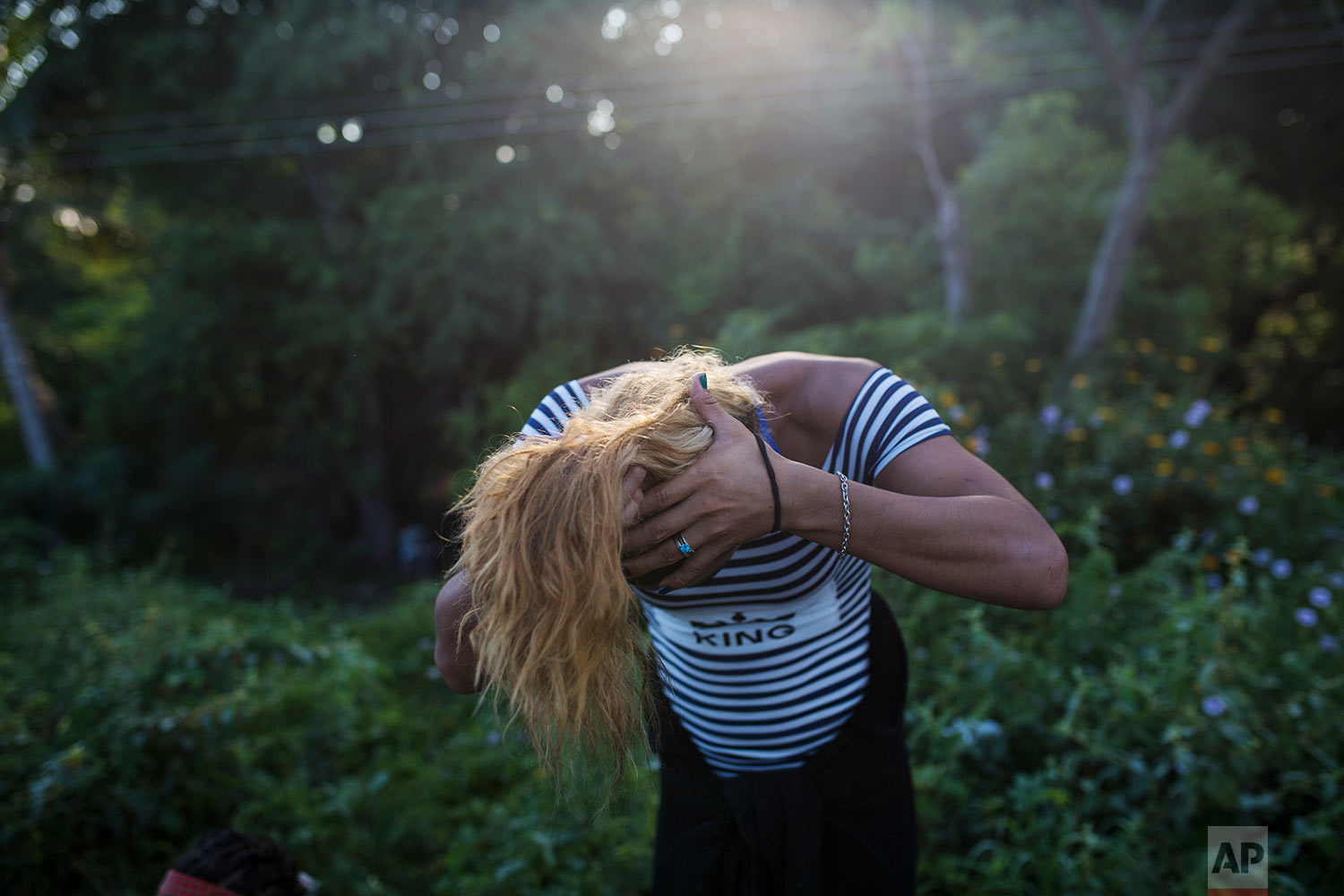  In this Nov. 2, 2018 photo, Honduran transgender Teresa Perez, who part of about 50 LGBTQ migrants traveling with the Central American migrants caravan hoping to reach the U.S. border, gathers her hair into a ponytail, on the outskirts of Donaji, Me