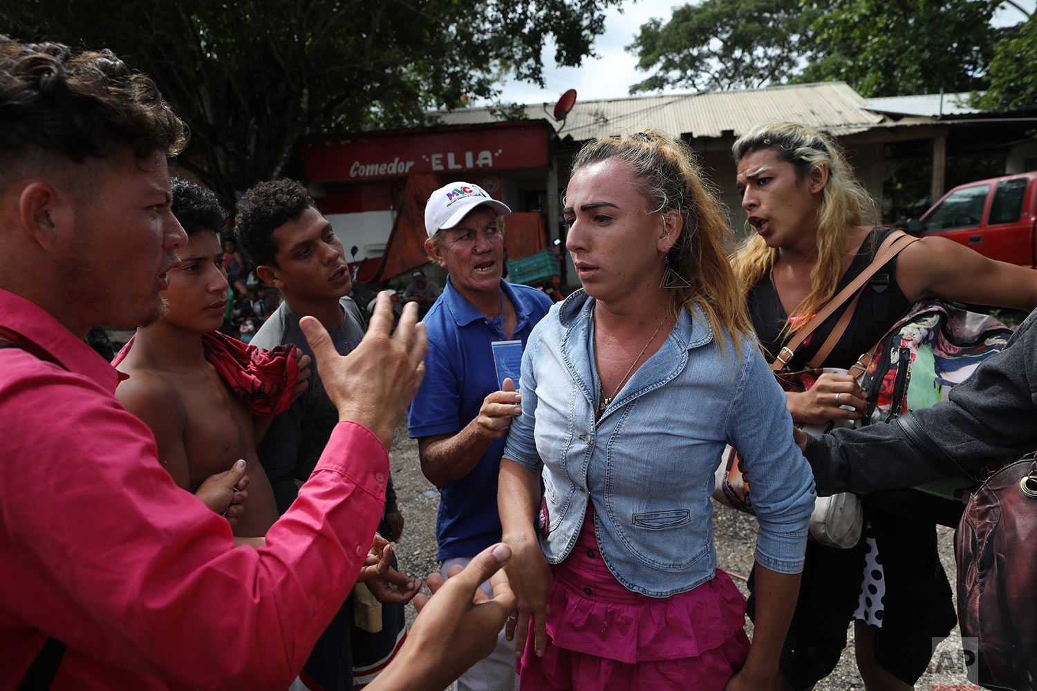  In this Nov. 3, 2018 photo, Honduran transgender Mariela Mejia, 22, who is traveling with the Central American migrants caravan hoping to reach the U.S. border, is pressured into sharing a wad of money given to her by a passerby, on the road to Isla