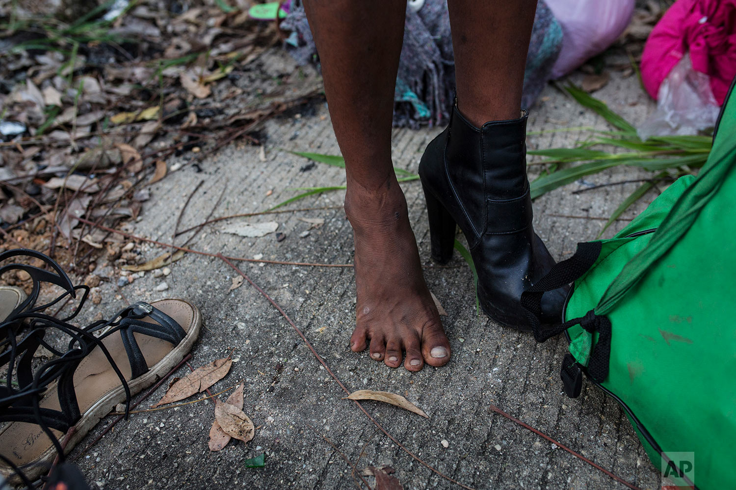  In this Nov. 3, 2018 photo, Honduran transgender Alexa Amaya, who is part of a group of 50 or so LGBTQ migrants traveling with the migrant caravan hoping to reach the U.S. border, tries on donated footwear at a shelter in Sayula, Mexico. (AP Photo/R