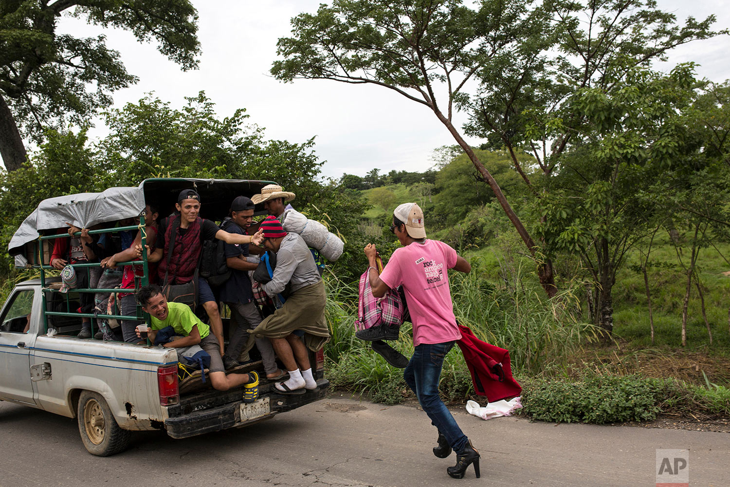  In this Nov. 2, 2018 photo, a member of about 50 LGBTQ migrants hoping to reach the U.S. border, chases after an overloaded pickup in hopes of hitching a ride to Donaji, Mexico. (AP Photo/Rodrigo Abd) 