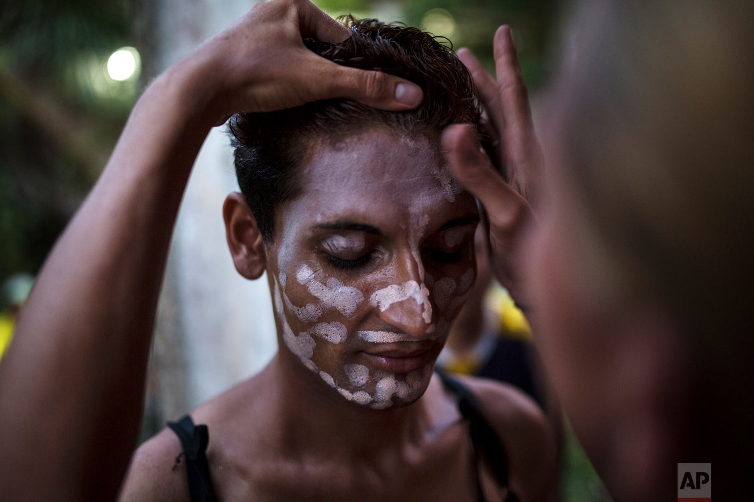  In this Nov. 1, 2018 photo, Honduran transgender Junior Castro, 22, who is part of the Central American migrants caravan hoping to reach the U.S. border, stands still as a friend applies foundation to her face, in Donaji, Mexico. (AP Photo/Rodrigo A
