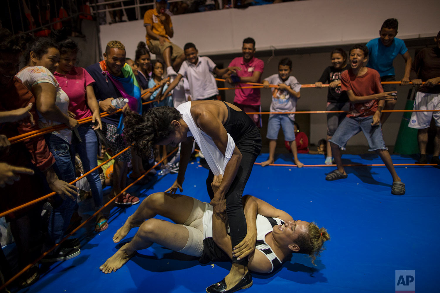  In this Nov. 4, 2018 photo, Nicaraguan transgender Sinai Cortez wrestles with her colleague Estrellita, of Honduras, because they were pressured by the men to get in the ring and battle it out, at a temporary shelter in Cordoba, Mexico. (AP Photo/Ro