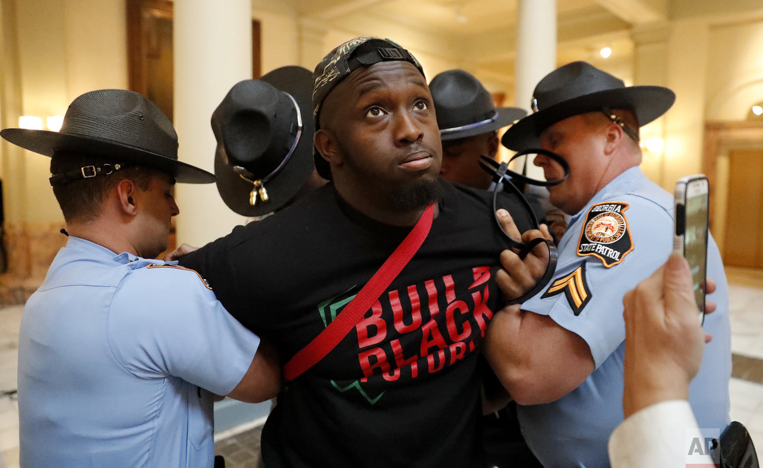 A man is arrested by Georgia state troopers during a protest over election ballot counts in the rotunda of the state Capitol building Tuesday, Nov. 13, 2018, in Atlanta. Several protesters, including a state senator, have been arrested during a demonstration at the Georgia state Capitol calling for tallying of uncounted ballots from the previous week's election. (AP Photo/John Bazemore)
