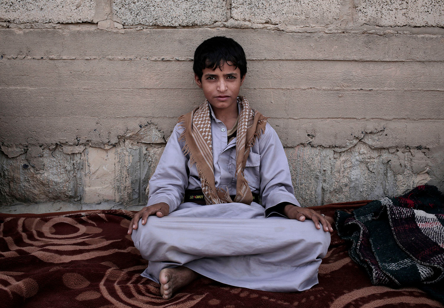 In this July 27, 2018 photo, 14 year-old Abdel Hamid Saleh, poses for a photograph at a camp for displaced persons where he took shelter, in Marib, Yemen. (AP Photo/Nariman El-Mofty)