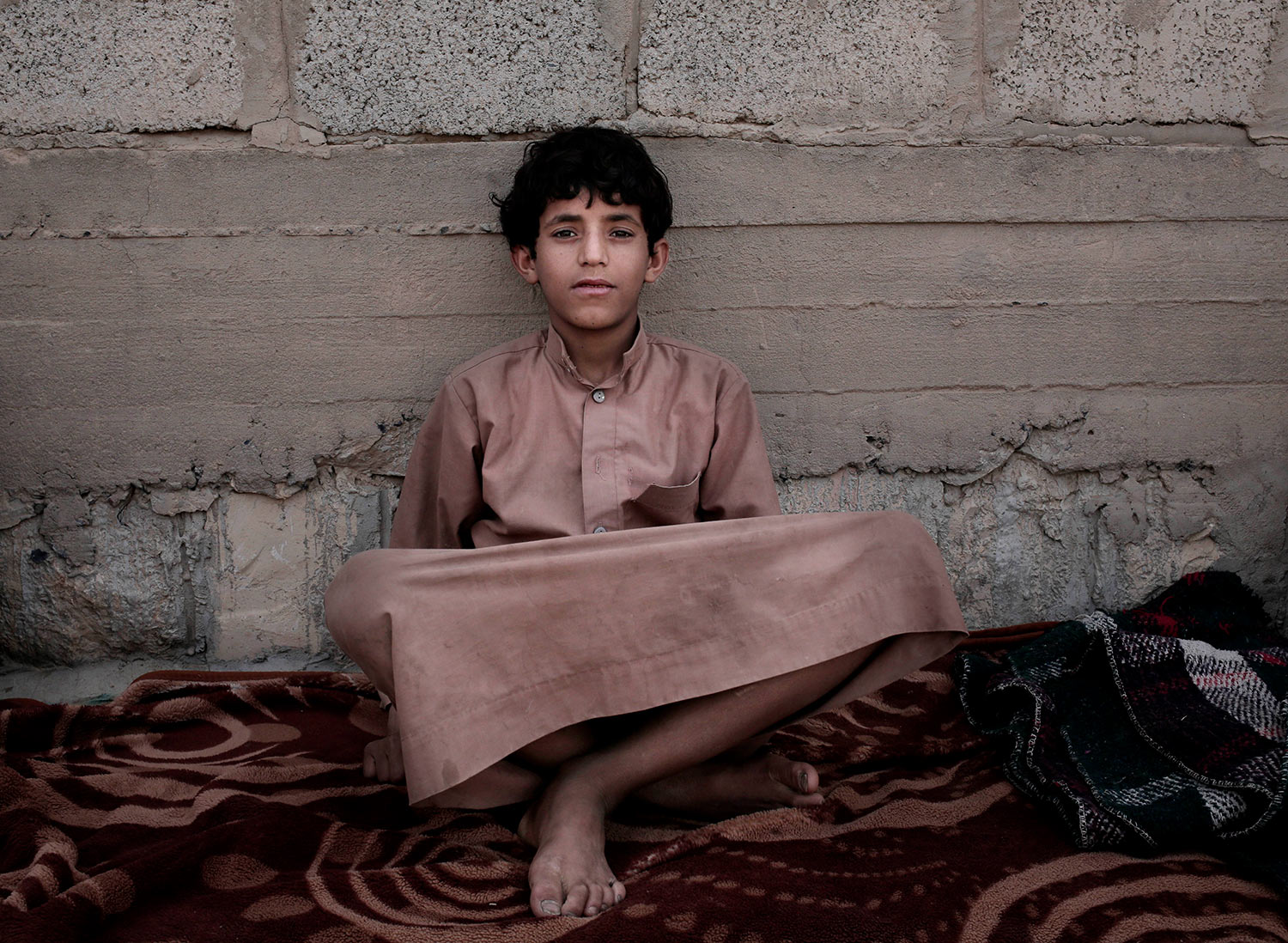 In this July 27, 2018 photo, 14 year-old Morsal Al Amery, poses for a photograph at a camp for displaced persons where he took shelter, in Marib, Yemen, (AP Photo/Nariman El-Mofty)