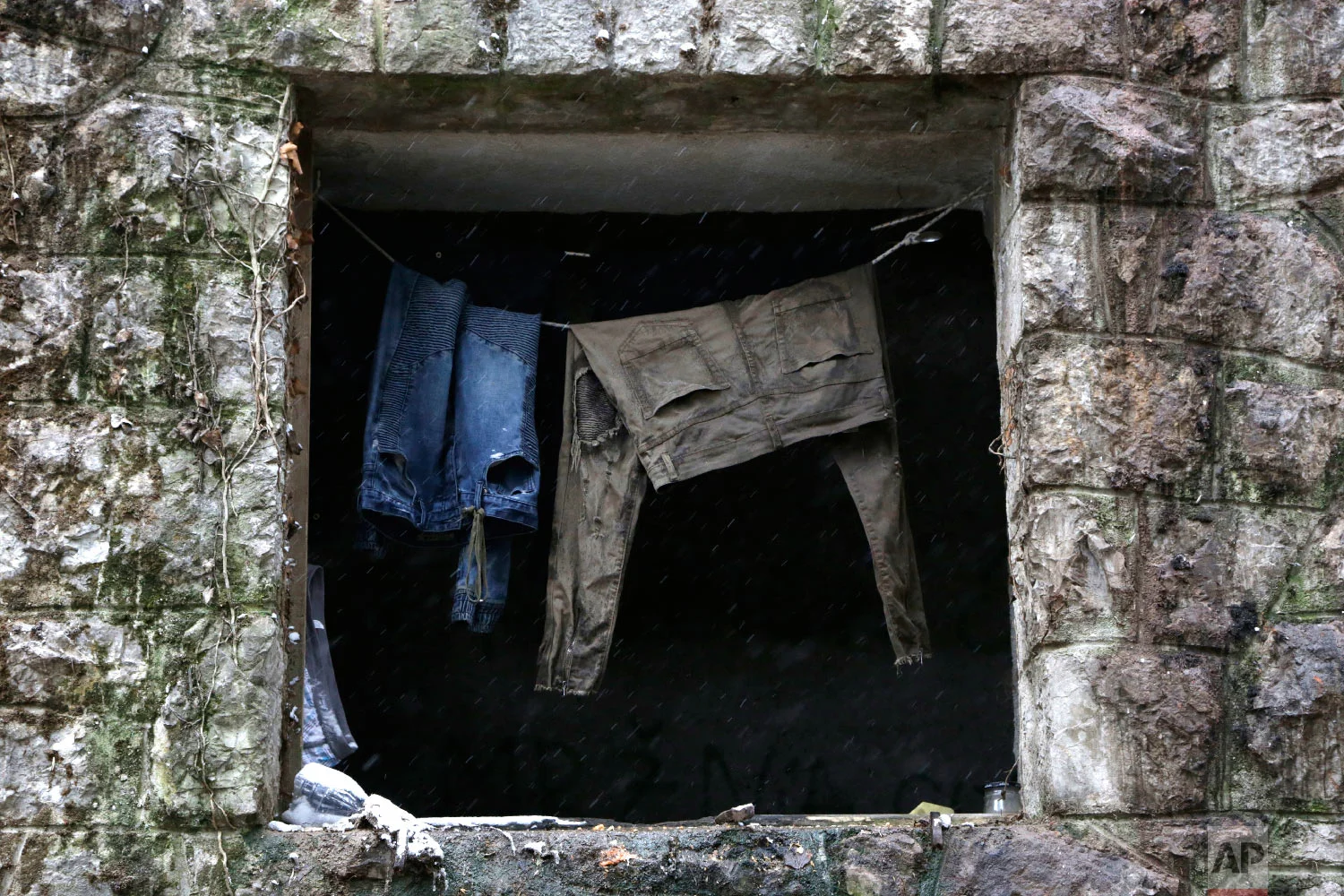Clothes hang from a rope at a window of a migrants shelter, in Bihac, Bosnia, close to the border to Croatia on Wednesday, Nov. 28, 2018. (AP Photo/Amel Emric)
