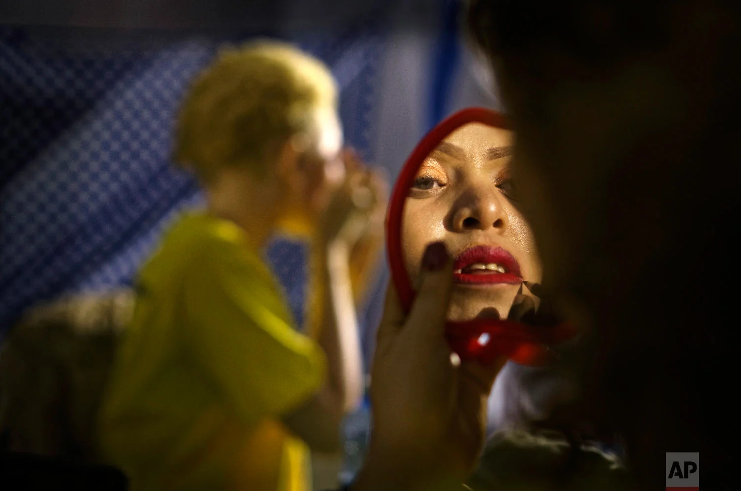 A contestant checks her makeup in a mirror as she prepares to perform in the Mr. & Miss Albinism East Africa contest, organized by the Albinism Society of Kenya, in Nairobi, Kenya, Nov. 30, 2018. (AP Photo/Ben Curtis)
