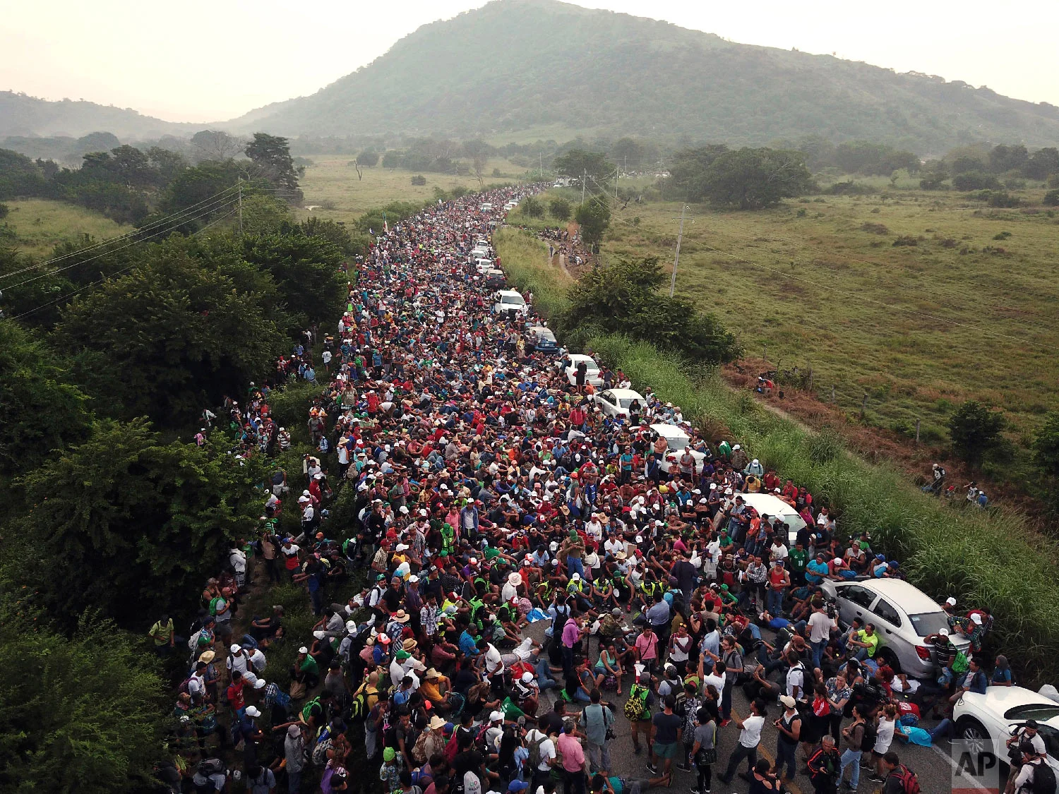 Members of a U.S.-bound migrant caravan stand on a road after federal police briefly blocked their way outside the town of Arriaga, Mexico, on Oct. 27, 2018. (AP Photo/Rodrigo Abd)