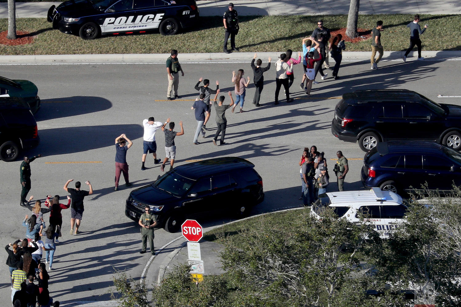  Students hold their hands in the air as they are evacuated by police from Marjory Stoneman Douglas High School in Parkland, Fla., on Feb. 14, 2018, after a shooter opened fire on the campus. (Mike Stocker/South Florida Sun-Sentinel via AP) 