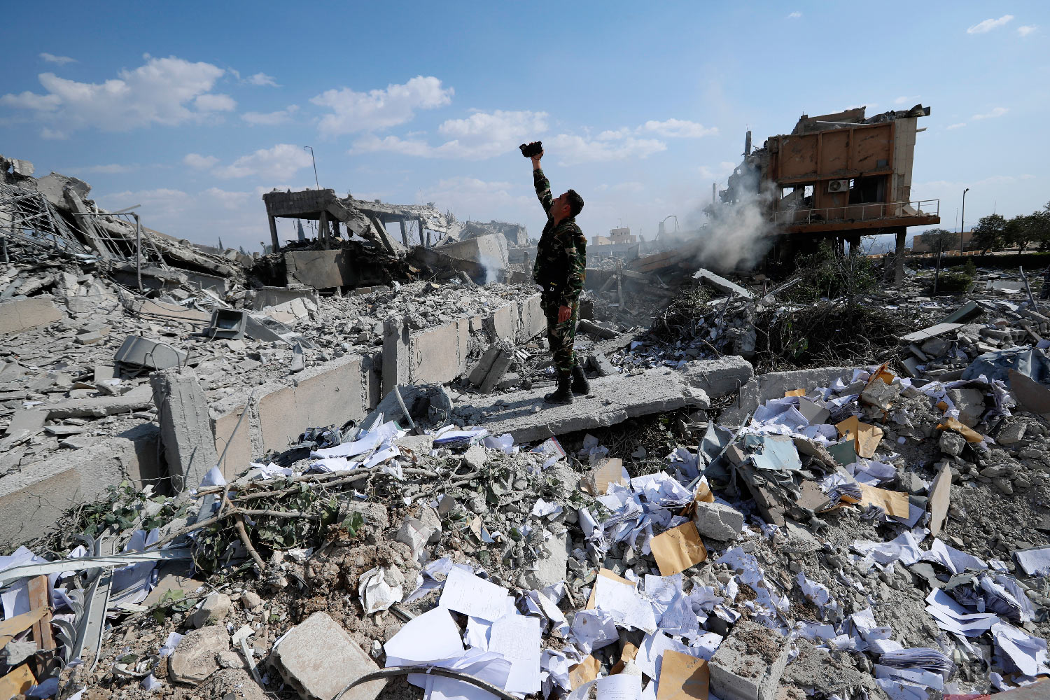  A Syrian soldier films the wreckage of the Syrian Scientific Research Center, which was attacked by U.S., British and French military strikes to punish President Bashar Assad for a suspected chemical attack against civilians, in the Damascus suburb 