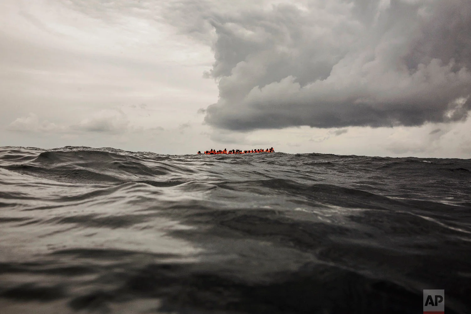 Refugees and migrants wait to be rescued by aid workers from the Spanish NGO Proactiva Open Arms, 60 miles north of Al-Khums, Libya, on Feb. 18, 2018, after leaving Libya aboard an overcrowded rubber boat in an attempt to reach European soil. (AP Photo/Olmo Calvo)