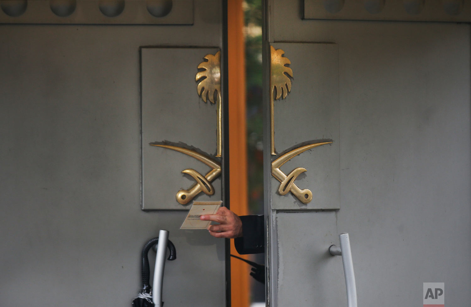  A security guard passes a document to a colleague outside Saudi Arabia's Consulate in Istanbul on Oct. 15, 2018, nearly two weeks after Saudi journalist Jamal Khashoggi was killed at the consulate. (AP Photo/Petros Giannakouris) 