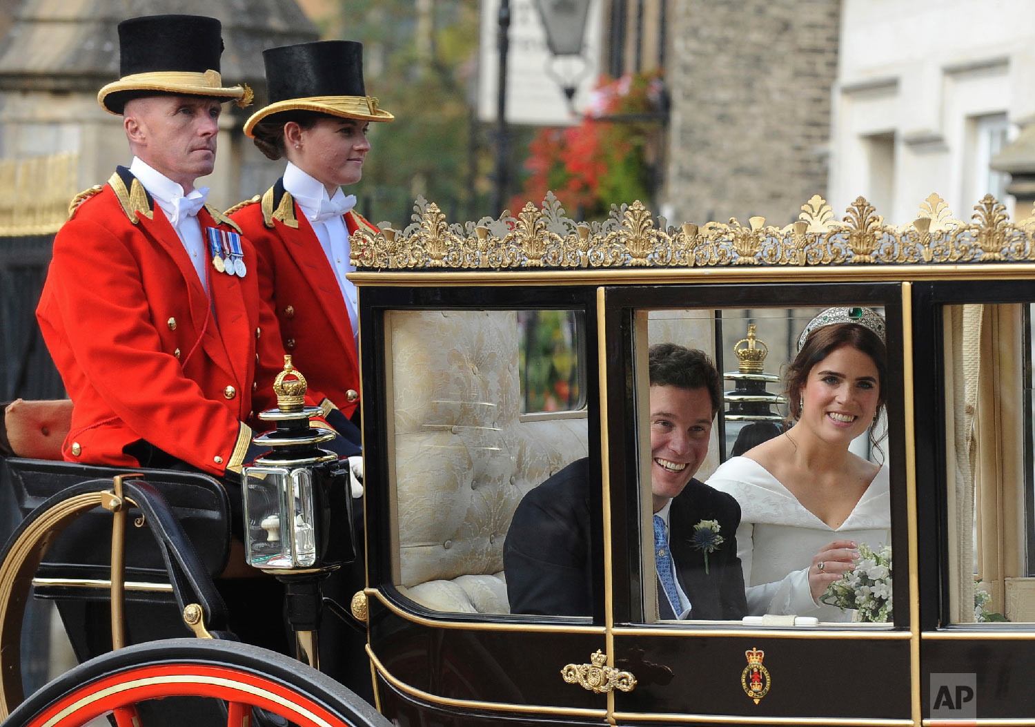  Princess Eugenie of York, right, and Jack Brooksbank look out from their carriage as they travel from St. George's Chapel to Windsor Castle after their wedding in Windsor, England, near London, on Oct. 12, 2018. (AP Photo/Rui Vieira) 