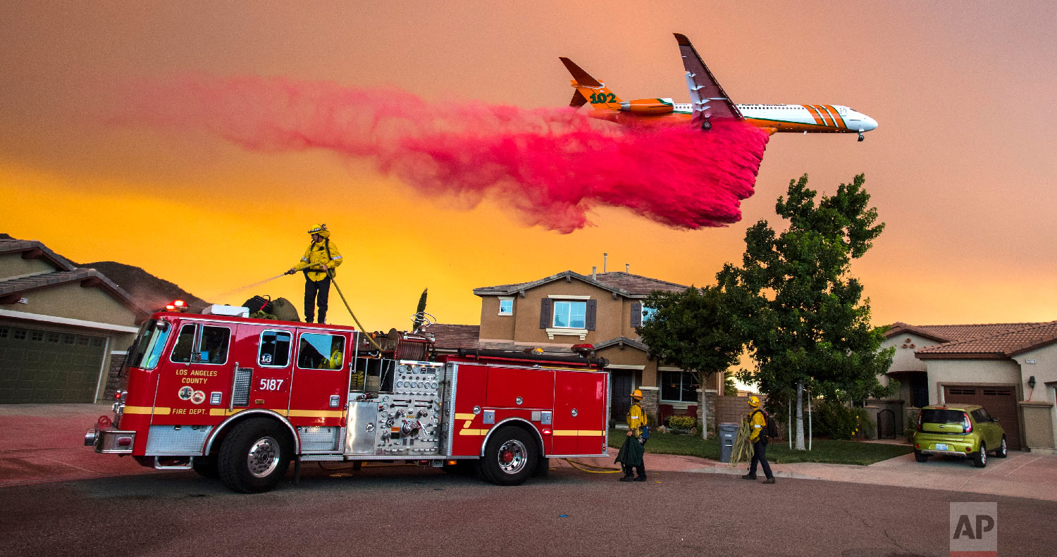  A plane drops fire retardant behind homes along McVicker Canyon Park Road in Lake Elsinore, Calif., as the Holy Fire burned near homes on Aug. 8, 2018. (Mark Rightmire/The Orange County Register via AP) 