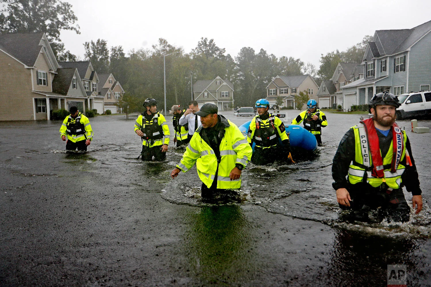 Members of the North Carolina Task Force urban search and rescue team wade through a flooded neighborhood looking for residents who stayed behind as Florence continues to dump heavy rain in Fayetteville, N.C., on Sept. 16, 2018. (AP Photo/David Goldman)