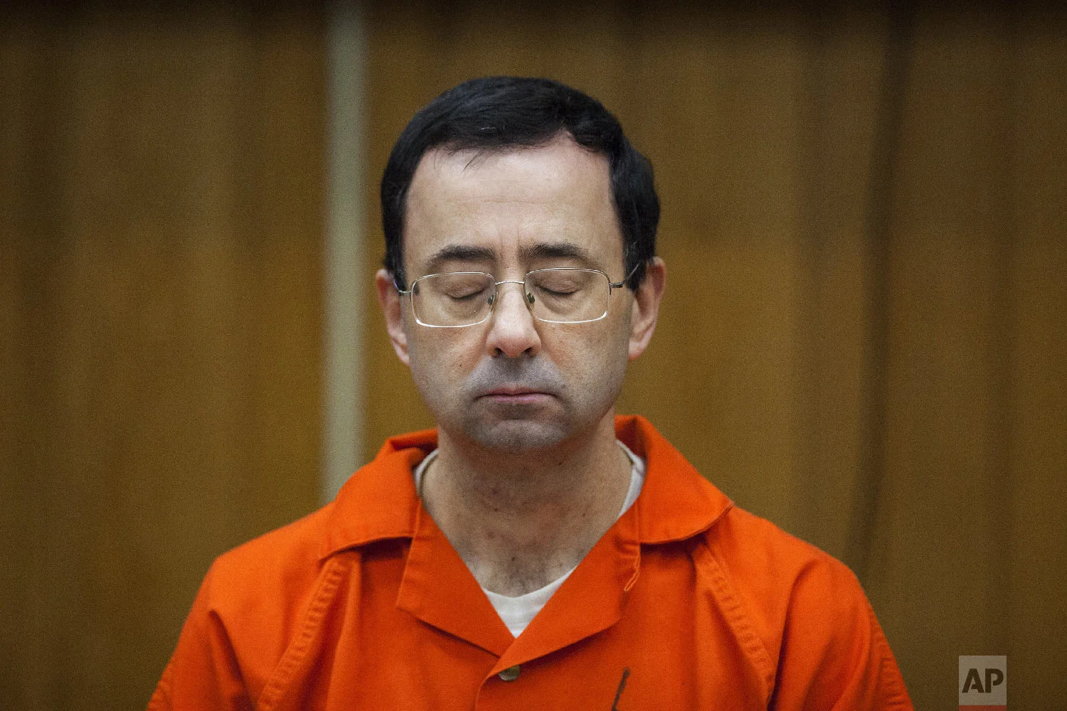 Larry Nassar listens during his sentencing at Eaton County Circuit Court in Charlotte, Mich., on Feb. 5, 2018. The former doctor for Michigan State University sports-medicine and USA Gymnastics received 40 to 125 years for three first degree criminal sexual abuse charges related to assaults at a gymnastics facility in Dimondale, Mich. Nassar has also been sentenced to 60 years in prison for three child pornography charges in federal court and between 40 to 175 years in Ingham County for seven counts of criminal sexual conduct. (Cory Morse /The Grand Rapids Press via AP)