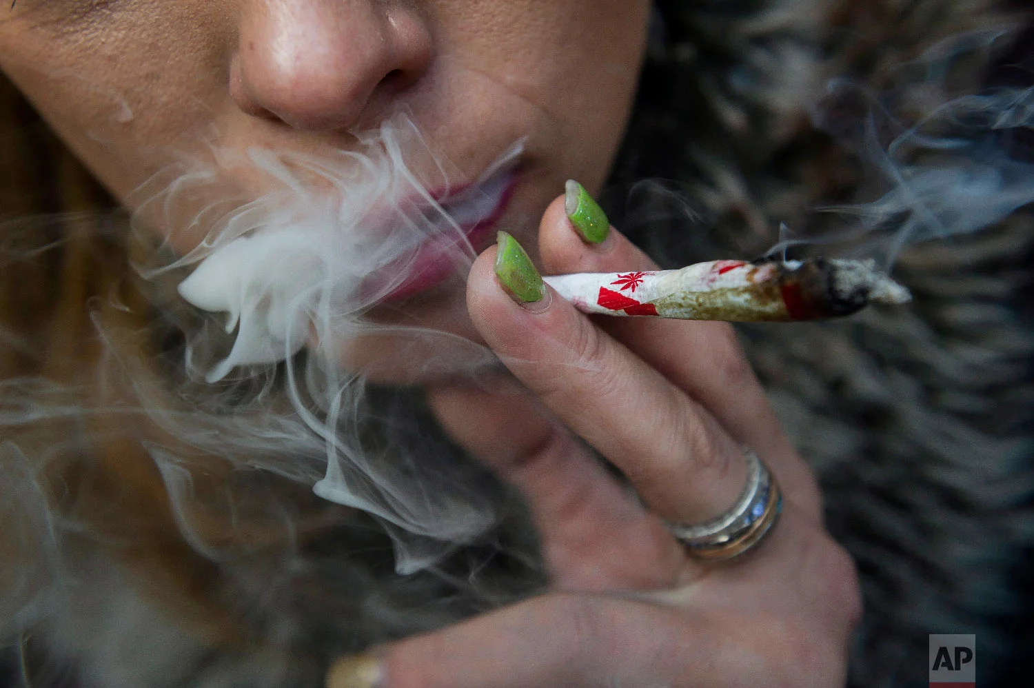 Krissy Calkins smokes a joint at a "Wake and Bake" legalized marijuana event in Toronto on Oct. 17, 2018, the day Canada became the largest country with a legal national marijuana marketplace. (Christopher Katsarov/The Canadian Press via AP)