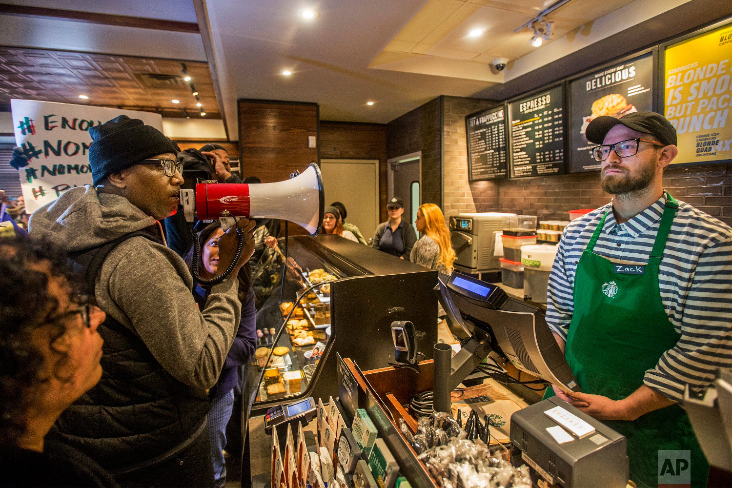  Local Black Lives Matter activist Asa Khalif, left, uses a megaphone inside a Starbucks on April 15, 2018, demanding the firing of the manager who called police on two black men who had entered the store, but didn’t make a purchase, resulting in the