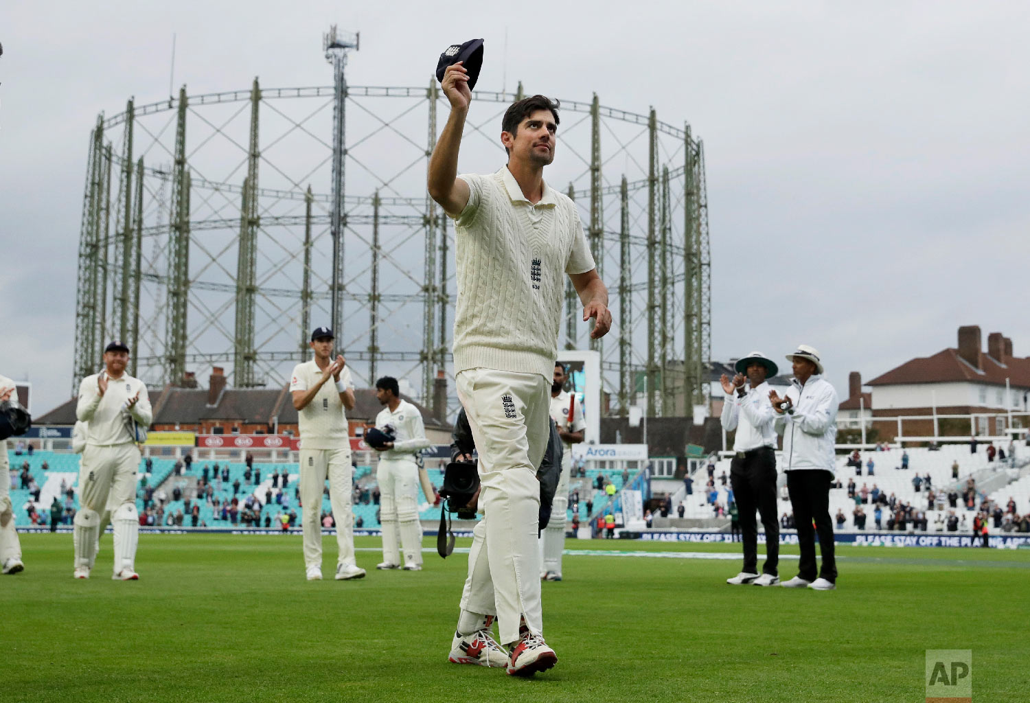  England's Alastair Cook, at the end of his final match before retiring from test cricket, raises his cap as he walks off at the end of the fifth cricket test match of a five match series between England and India at the Oval cricket ground in London