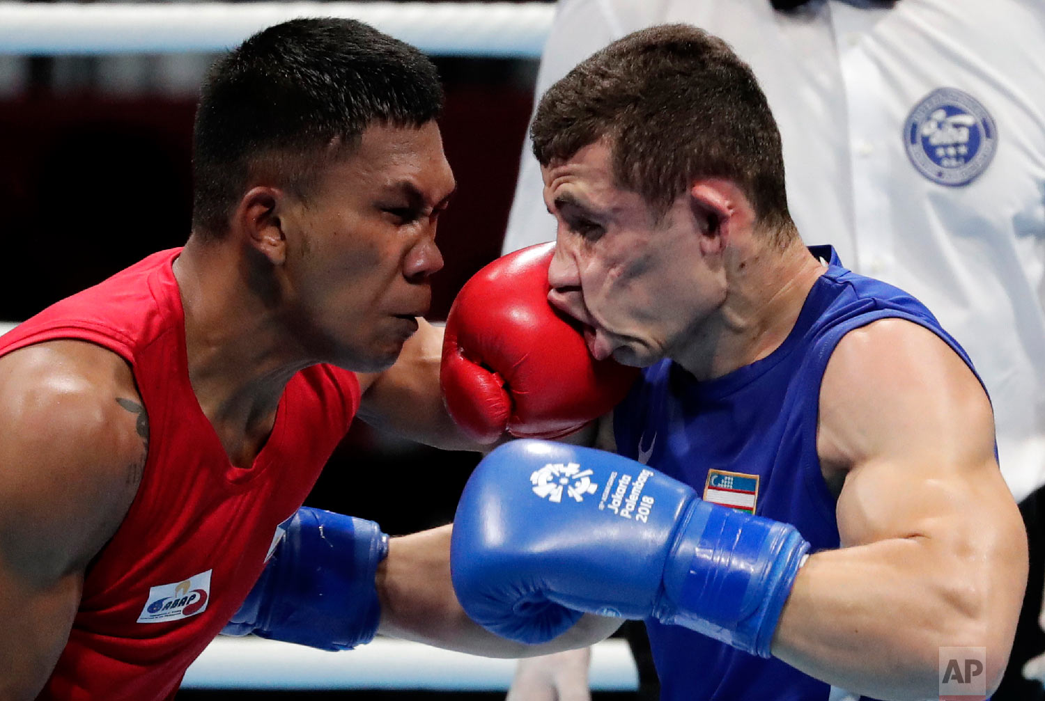  Phillippines' Eumir Felix Marcial, left, lands a blow on the face of Uzbekistan's Israil Madrimov during their men's middleweight boxing semifinal at the 18th Asian Games in Jakarta, Indonesia, on Aug. 31, 2018. (AP Photo/Lee Jin-man) 