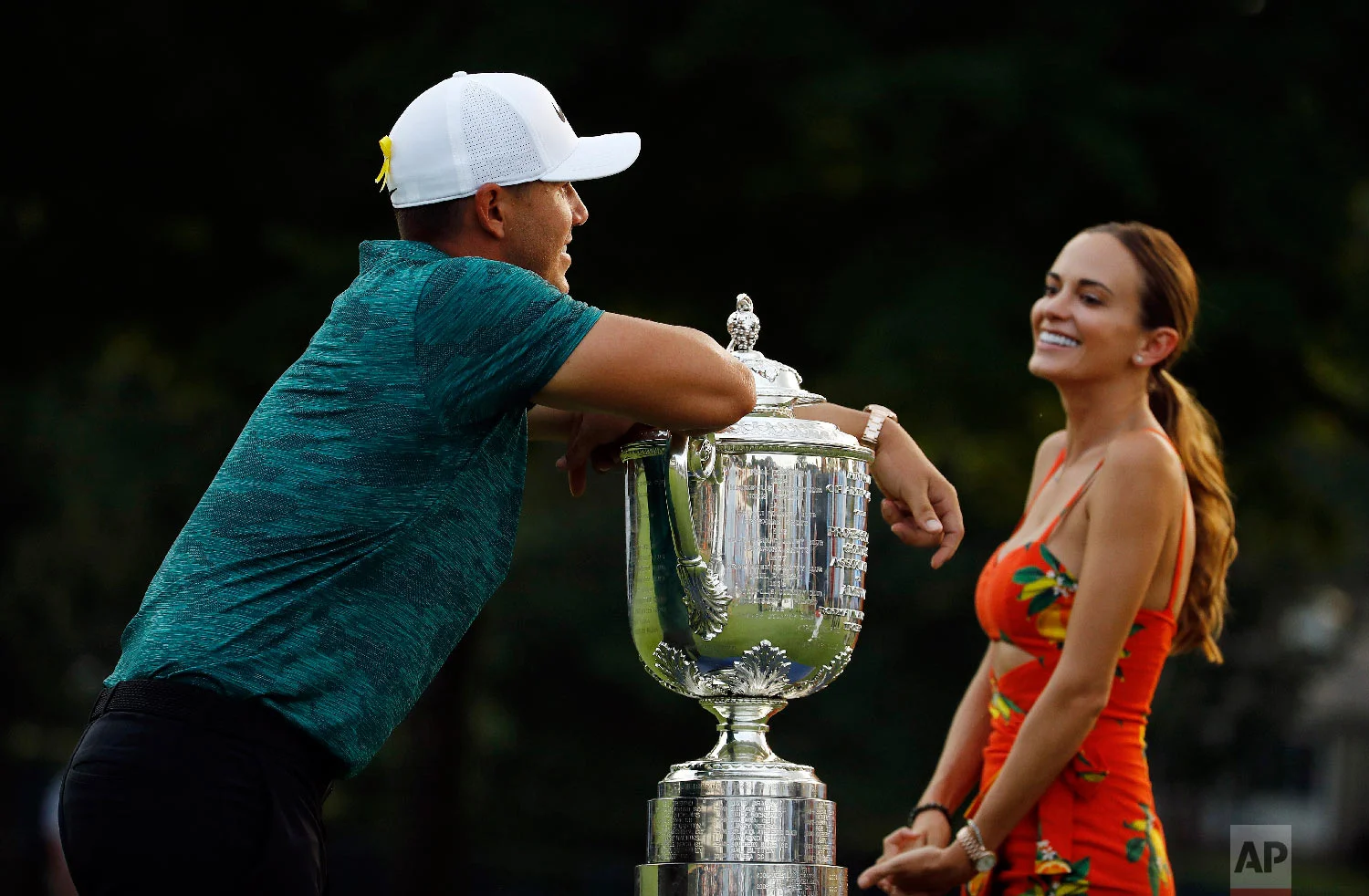 Brooks Koepka leans on the Wanamaker Trophy as he talks with his girlfriend, Jena Sims, after winning the PGA Championship golf tournament at Bellerive Country Club in St. Louis on Aug. 12, 2018. (AP Photo/Charlie Riedel)