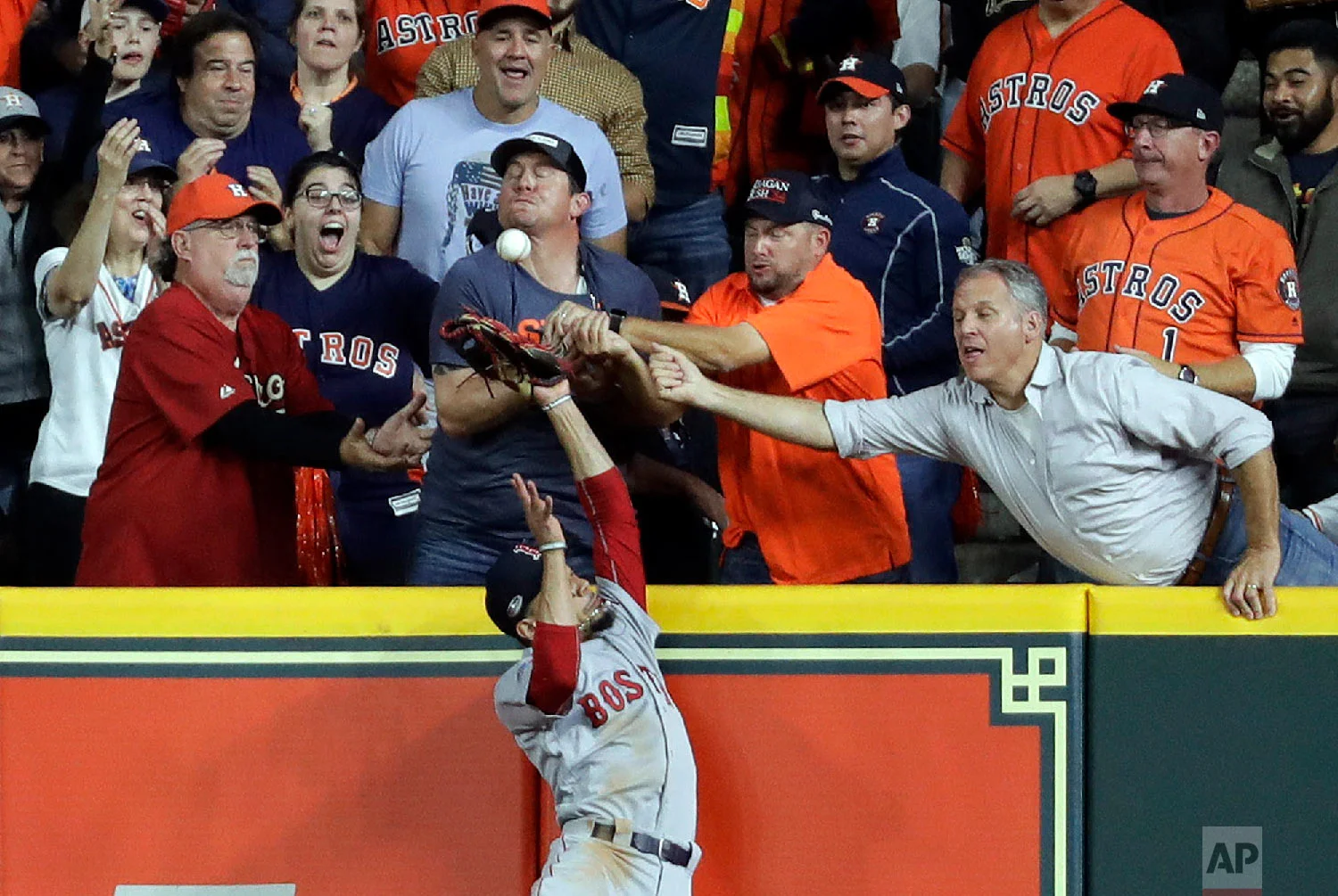 Fans interfere with Boston Red Sox right fielder Mookie Betts trying to catch a ball hit by Houston Astros' Jose Altuve during the first inning in Game 4 of a baseball American League Championship Series on Oct. 17, 2018, in Houston. Altuve was called out. (AP Photo/Frank Franklin II)