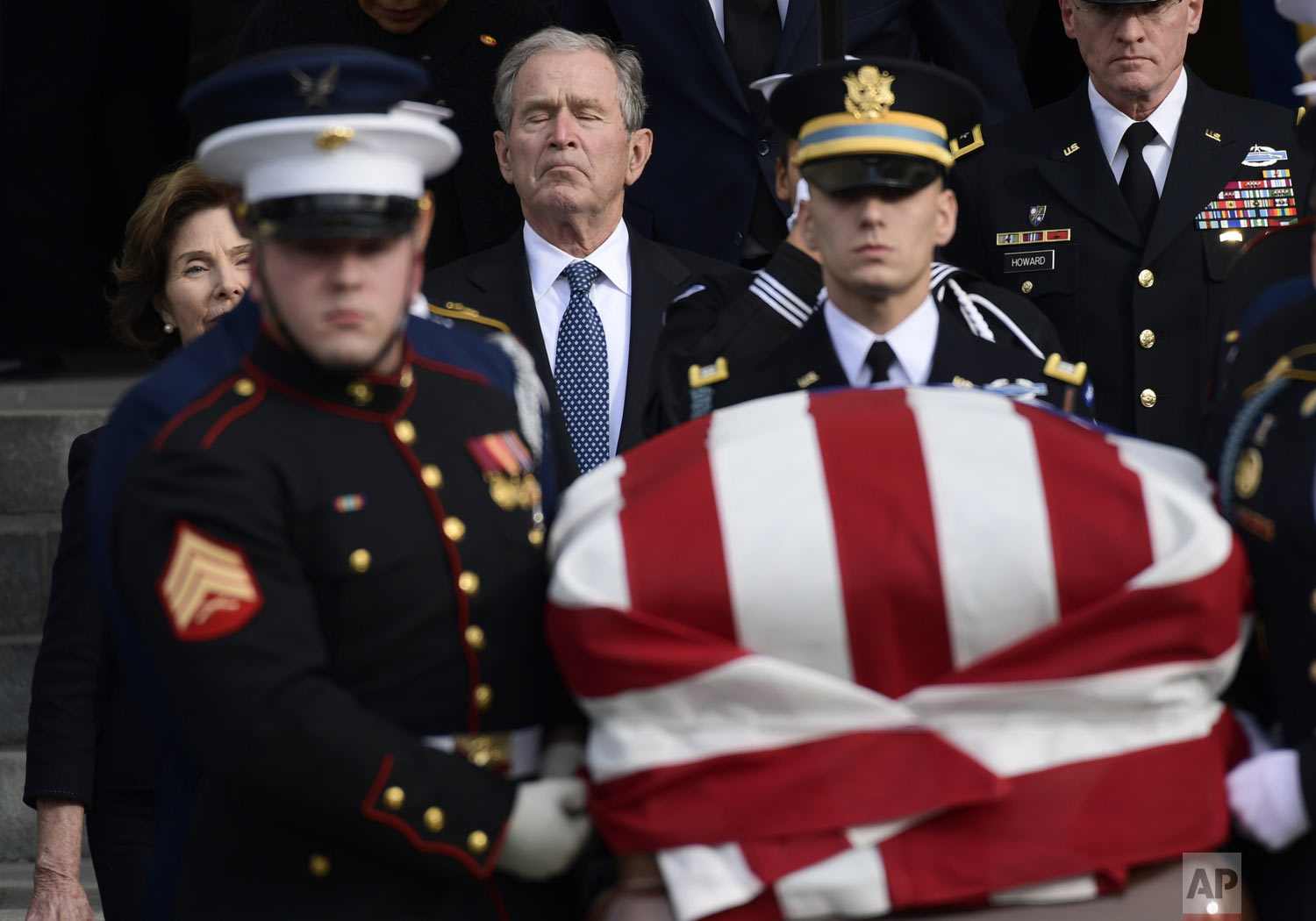  Former President George W. Bush and former first lady Laura Bush, left, follow the casket of former President George H.W. Bush, carried out following a State Funeral at the National Cathedral in Washington, Wednesday, Dec. 5, 2018. (AP Photo/Susan W